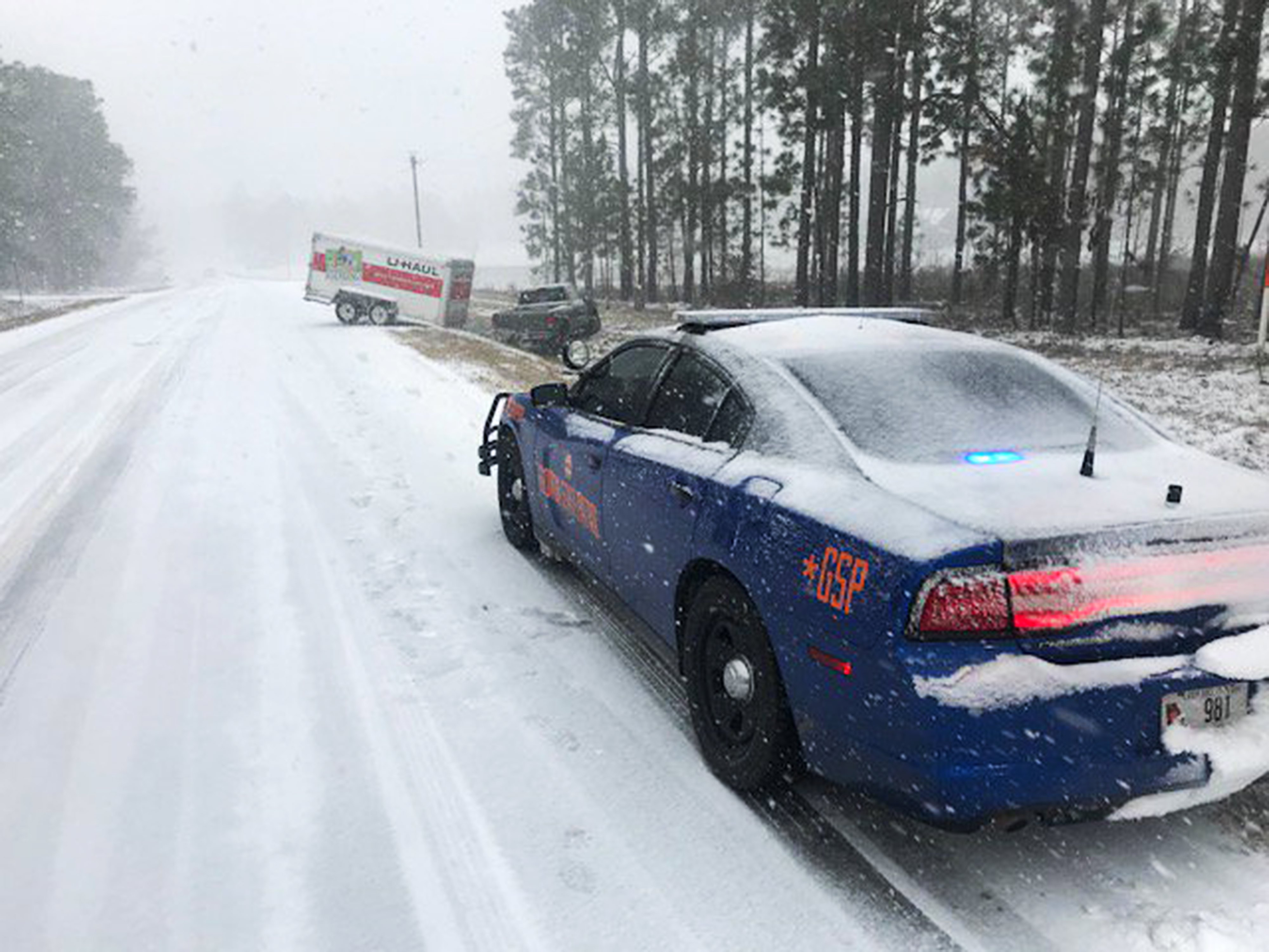 epa06415147 A handout photo made available by Georgia Department of Public Safety shows a Georgia State Patrol Dodge Charger at the scene of a crash involving a U-Haul trailer and pick-up truck on State Route 135 in Montgomery County near Uvalda, Georgia 03 January 2018. The unusual but light snow falling in the Southern US is part of a storm which will rapidly strengthen into a major winter storm for the Northeast on 04 January 2018. More than a foot of snowfall (30cm) and wind gusts of more than 50 mph (80 kph) are forecast for Boston, Massachusetts.  EPA/GEORGIA STATE PATROL / HANDOUT HANDOUT  HANDOUT EDITORIAL USE ONLY/NO SALES