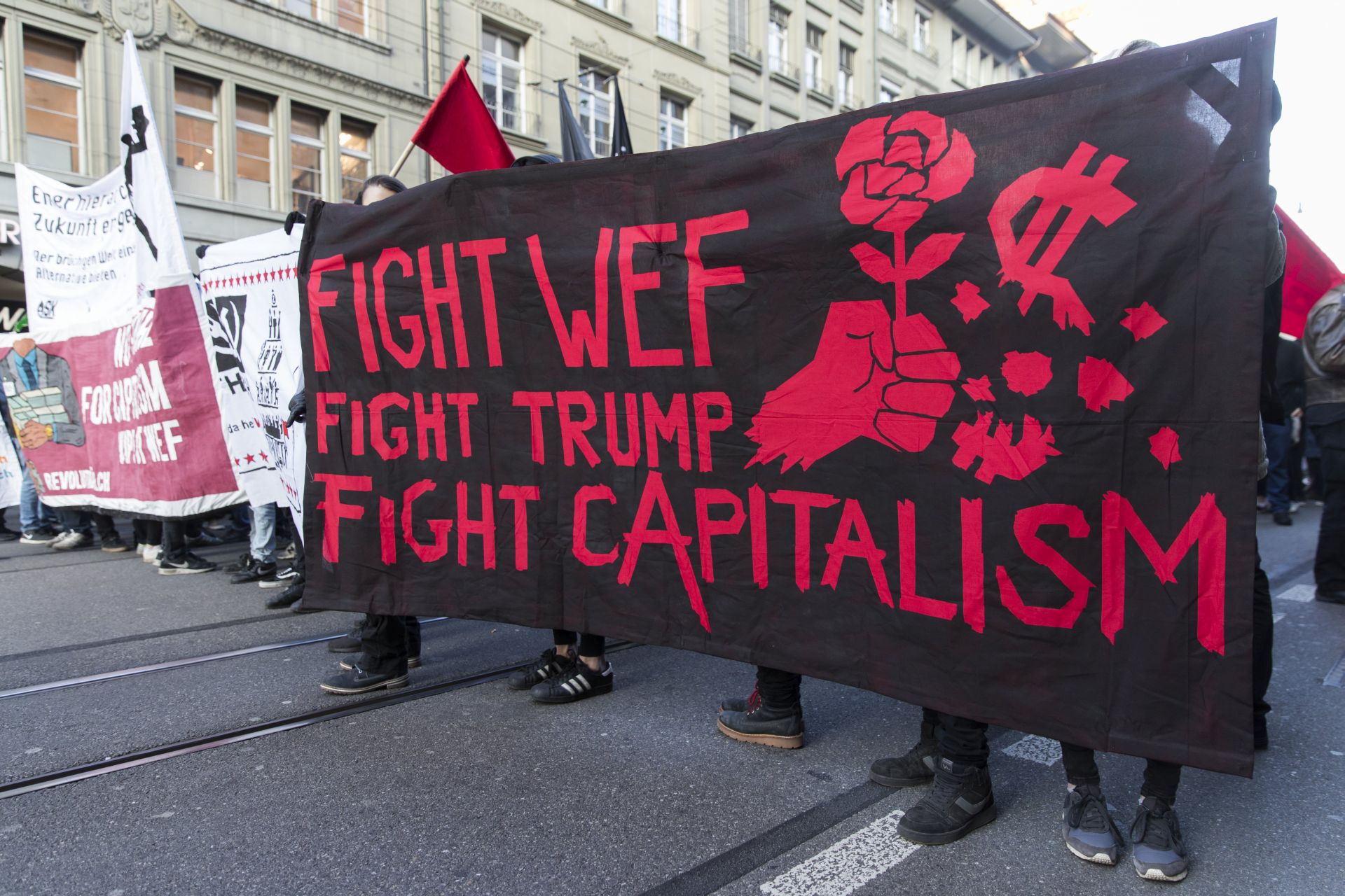 epa06435982 Protesters march with banners during a demonstration against the World Economic Forum (WEF) and US president Donald Trump, in Bern, Switzerland, 13 January 2018. The WEF will take place from January 23 till January 26 in Davos.  EPA/PETER KLAUNZER