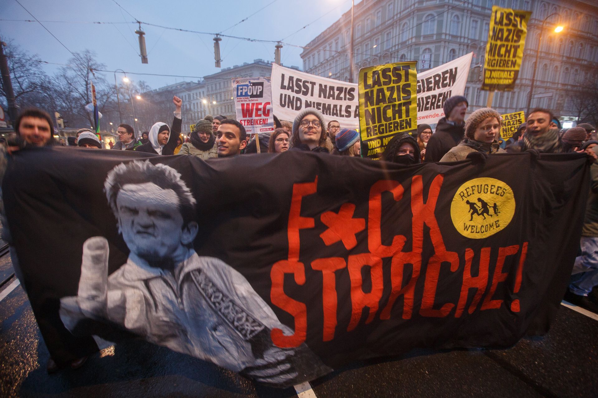 epa06436246 People carry a banner reading 'f'ck strache' as they take part in a protest against the new coalition government between Austrian Peoples Party (OeVP) and the right-wing Austrian Freedom Party (FPOe) in Vienna, Austria, 13 January 2018. About 20,000 people took part in the demonstration organized by NGOs, refugee initiatives, political and civic organizations to protest against racism and social cuts of the new Austrian government.  EPA/FLORIAN WIESER