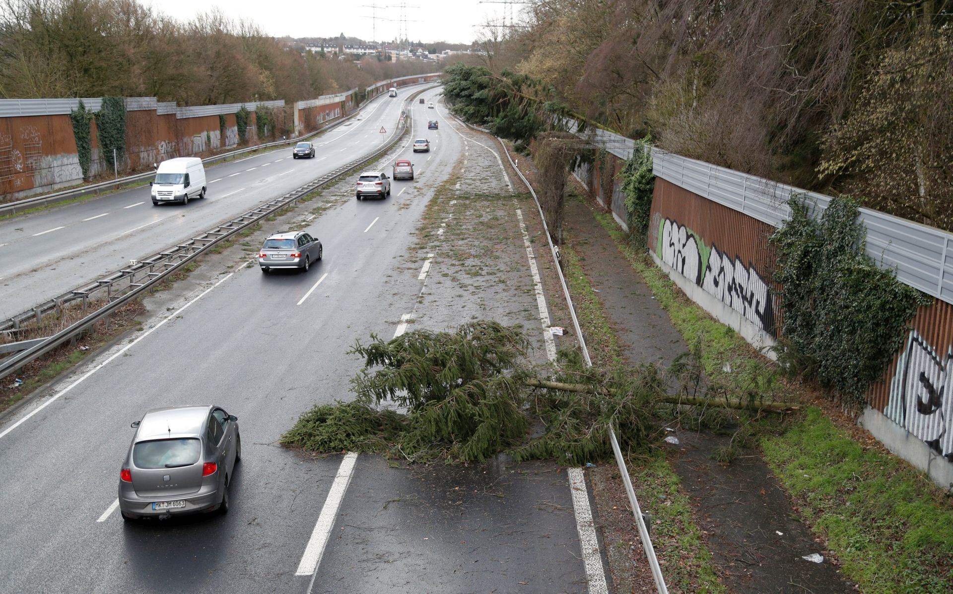 epa06449941 Cars drive around fallen trees near Dortmund, Germany, 18 January 2018. The storm depression 'Friedrike' is forecast to cause hurricane and heavy rain or snowfall in Germany.  EPA/FRIEDEMANN VOGEL