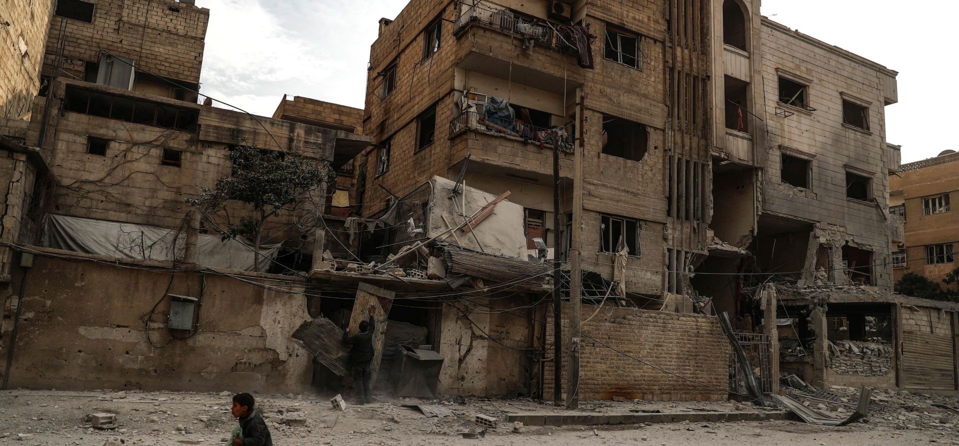 epa06507301 A boy runs next to destroyed buildings after a bombing in Douma, eastern Ghouta, Syria, 08 February 2018 (issued 09 February 2018). According to media reports, 75 people were killed in attacks allegedly carried out by forces loyal to the Syrian government on the rebel-held areas of eastern-Ghouta.  EPA/MOHAMMED BADRA