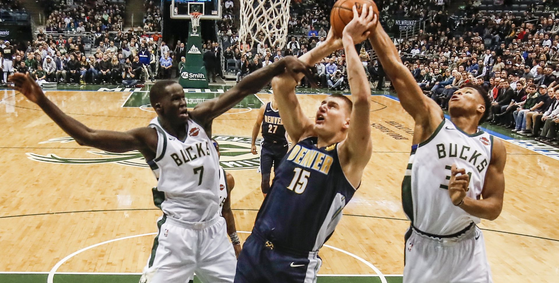 epa06530456 Denver Nuggets center Nikola Jokic of Serbia (C) shoots between Milwaukee Bucks center Thon Maker of Australia (L) and  Milwaukee Bucks forward Giannis Antetokounmpo of Greece (R) in the first  half of their NBA game at the BMO Harris Bradley Center in Milwaukee, Wisconsin, USA, 15 February 2018.  EPA/TANNEN MAURY  SHUTTERSTOCK OUT
