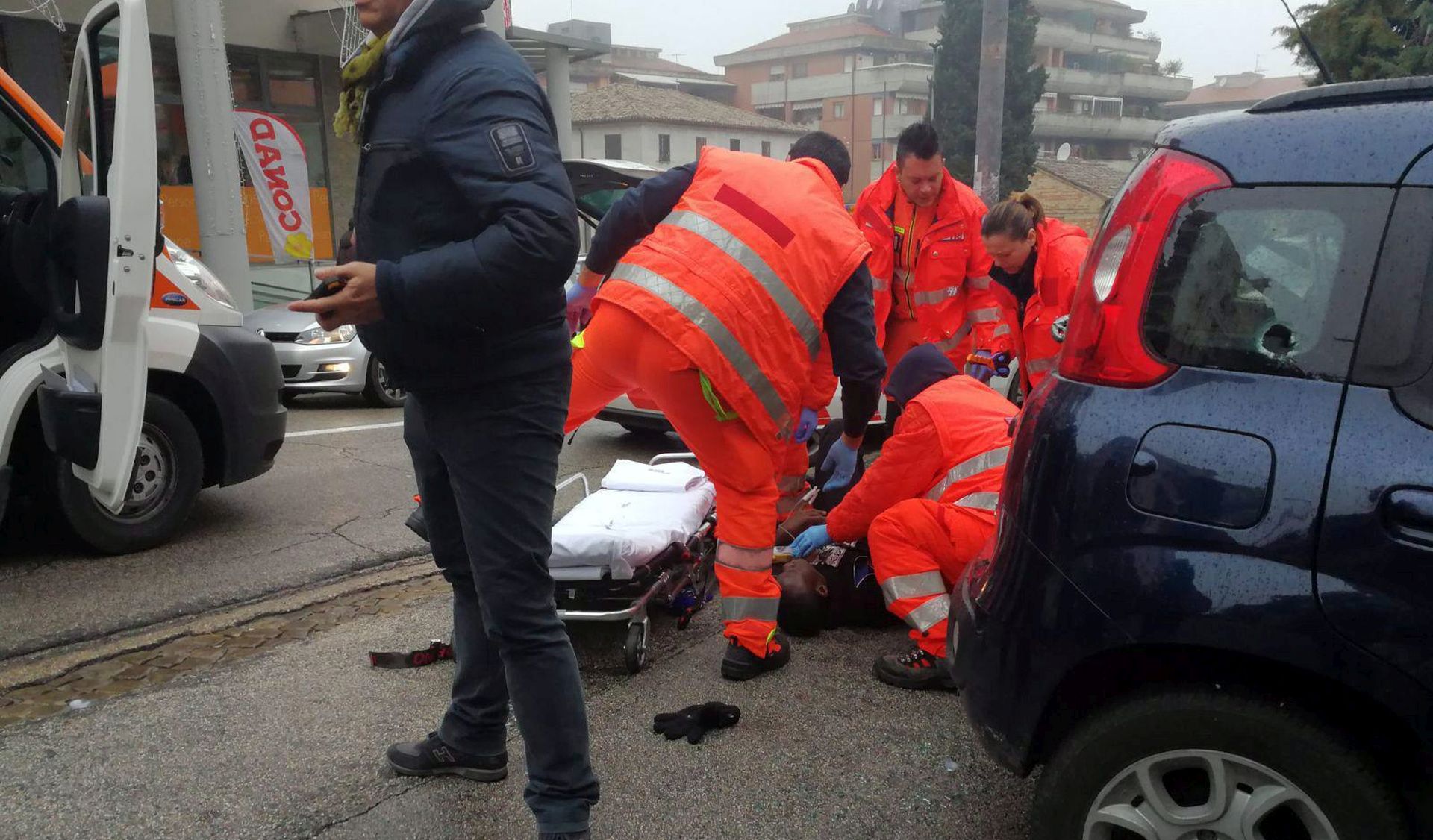 epa06493399 Paramedics treat an injured person that was shot from a passing vehicle in Macerata, Italy, 03 February 2018. According to the local authorities, the town at the eastern Italian coast near Ancona is under a lockdown due to shots being fired from a car that is driving around in the town for yet unknown reasons.  EPA/GUIDO PICCHIO