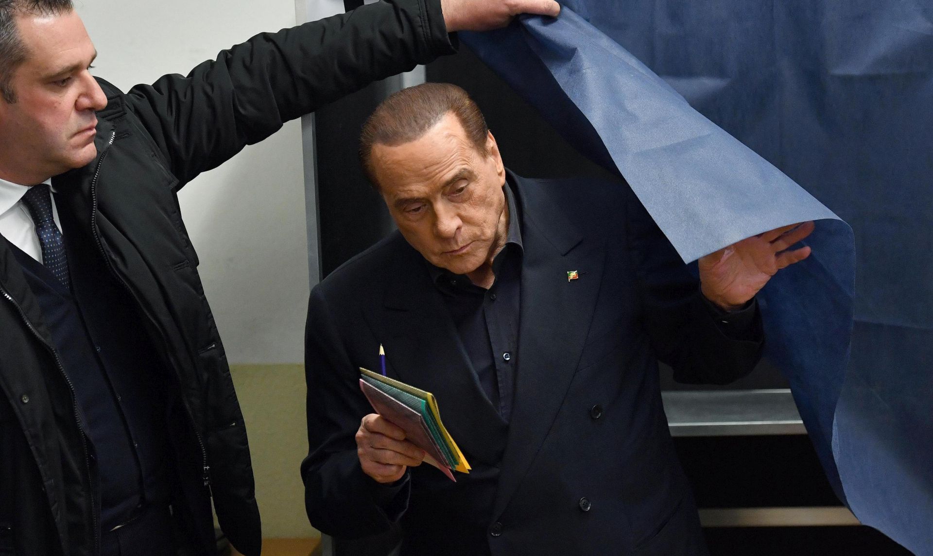 epa06578816 Former Italian Prime Minister and leader of the 'Forza Italia' party, Silvio Berlusconi (R), leaves a booth prior to casting his vote for the general elections at a polling station in Milan, Italy, 04 March 2018. Berlusconi's visit to the polling station was interrupted by a 'Femen' protester with a slogan 'Berlusconi you are expired' painted on her bare chest. General elections are held in Italy on 04 March 2018 with the country's economic situation and migrant influx in the past years believed to dominate the voters' decisions. The three main political contenders in Italy, the right-wing coalition, the ruling Democratic Party and the anti-establishment 5-Star-Movement have all predicted major results for themselves. The final results of the elections are expected to be announced on early 05 March.  EPA/DANIEL DAL ZENNARO