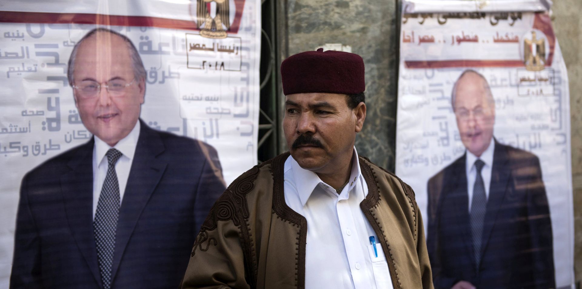 epa06617948 A man stands between posters for Presidential candidate Moussa Mostafa Moussa, Leader of the Egyptian liberal el-Ghad Party, in Cairo, Egypt, 21 March 2018. Egyptian Presidential election will be held between 26 and 28 March 2018. Moussa Mostafa Moussa, the head of el-Ghad party is running against Incumbent President Abdel Fattah al-Sisi.  EPA/MOHAMED HOSSAM