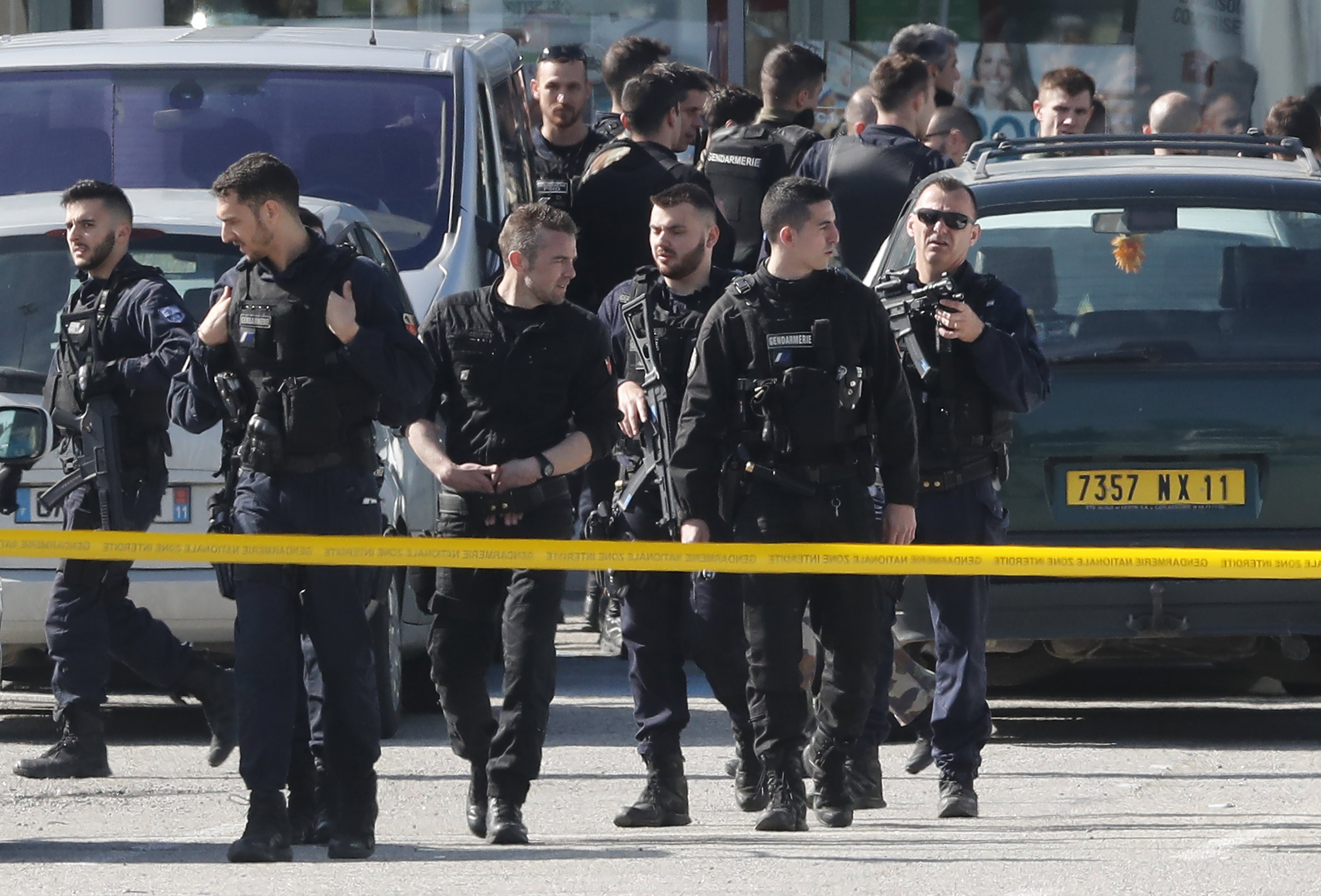 epa06623763 Armed gendarmes are seen on the parking lot after their assault on the Super U supermarket where a gunman claiming allegiance to the Islamic State (IS) was holding hostages in Trebes, southern France, 23 March 2018. French police are launching a raid on the supermaket where a gunman that allegedly pledged alliance to the IS is holding hostages. Police says at least two people died and dozens were injured in Trebes near Carcassonne.  EPA/GUILLAUME HORCAJUELO