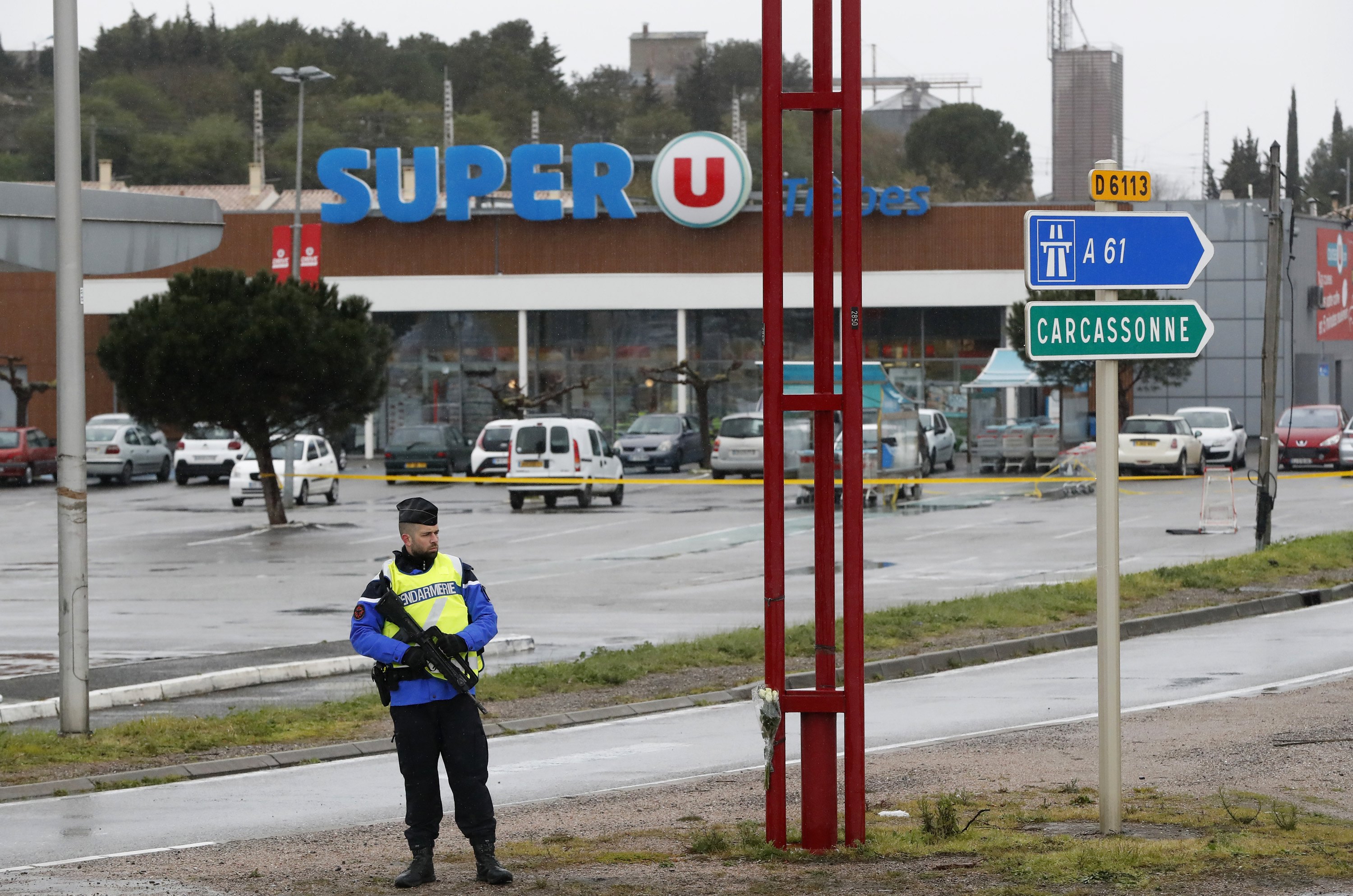epa06625997 A Gendarme secures the parking lot of the Super U supermarket a day after terrorist attack in Trebes, southern France, 24 March 2018. A gunman, claiming allegiance to the Islamic State (IS) took hostages iat the Super U supermarket on 23 March in Trebes. According to reports four people died, including a police officer who voluntary replaced a female hostage, and 16 others were injured in the attack. French Police has shot dead the attacker in Trebes near Carcassonne following the hostage situation.  EPA/GUILLAUME HORCAJUELO