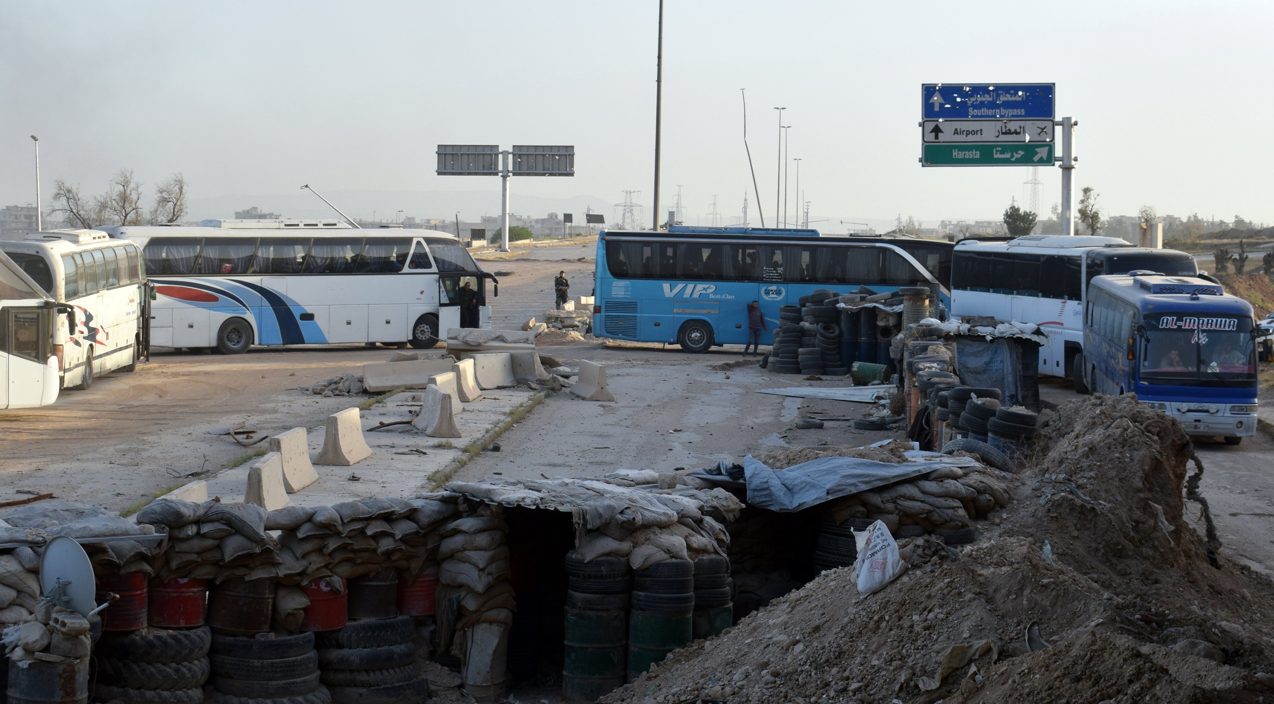 epa06629427 Syrian government buses carrying people drive out from Erbin town, Eastern Ghouta, Damascus countryside, Syria, 25 March 2018. According to media reports, some 3,708 militants and their relatives boarding 52 buses left on 25 March the rebels-held suburbs of Jobar, Ein Tarma, Zamalka and Erbin to the northwestern city of Idleb. The first batch left a day earlier.  EPA/STR