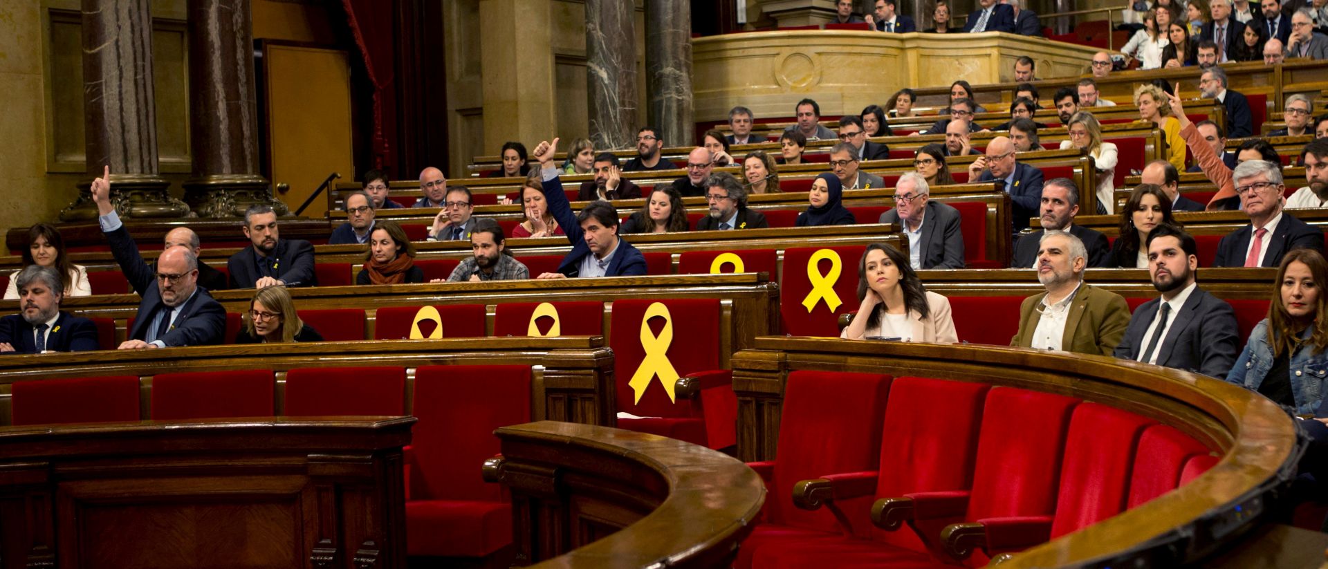 epa06633934 A general view of Catalan regional Parliament with several empty seats with yellow ribbons, in support of Catalan pro-independence activists and politicians imprisoned, during a plenary session at Catalan regional Parliament, in Barcelona, northeastern Spain, 28 March 2018. Two proposals, issued by the pro-independence political groups JxCat, ERC and CUP on the right of the defendants Carles Puigdemont, Jordi Sanchez and Jordi Turull to be sworn in as regional president, are to debate in the session.  EPA/Quique Garcia