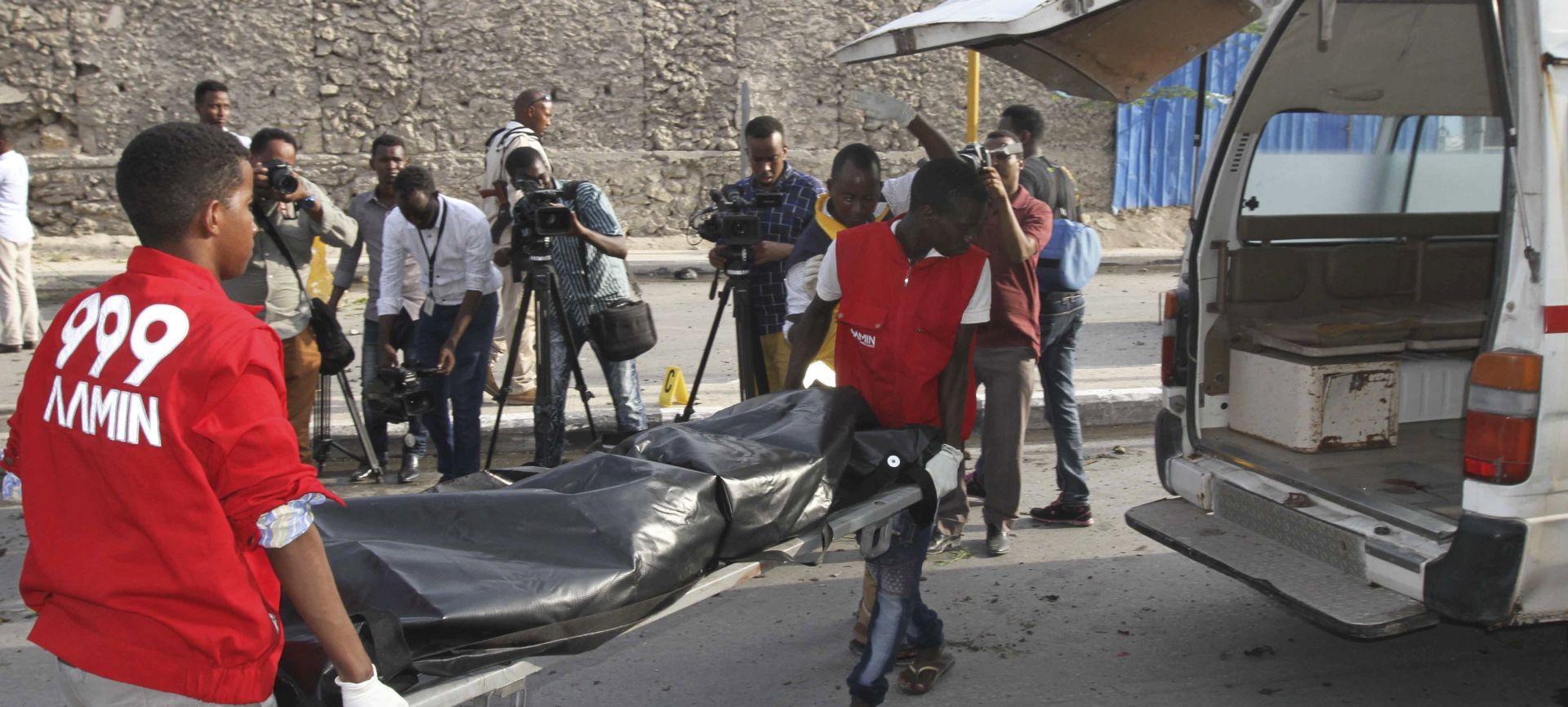 epa06628954 Medics carry the body of a victim on a stretcher into an ambulance at the scene of a car bomb explosion in the capital Mogadishu, Somalia, 25 March 2018. Reports say a car bomb went off near the parliament in the capital, killing at least four people. There was no immediate claim of responsibility for the latest attack that followed similar one on 22 March. Somalia's Islamist militant group al-Shabab often carries out such attacks against Somalia's fragile western-backed government.  EPA/SAID YUSUF WARSAME
