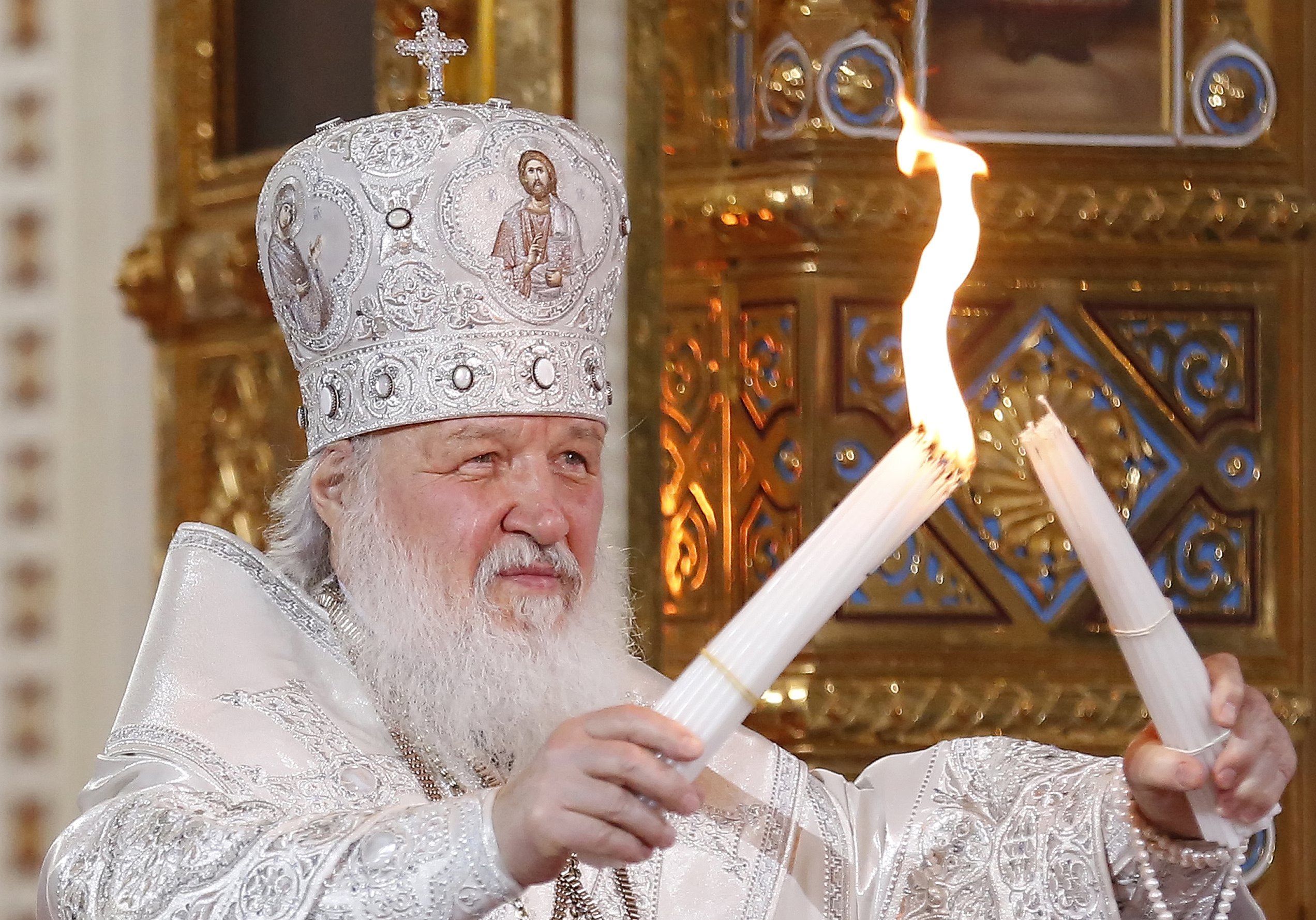 epa06653778 Patriarch Kirill of Moscow and All Russia burns candles from the Holy Fire brought from Jerusalem during the Orthodox Easter holiday service at the Christ the Savior Cathedral in Moscow, Russia, late 07 April 2018.  EPA/SERGEI ILNITSKY