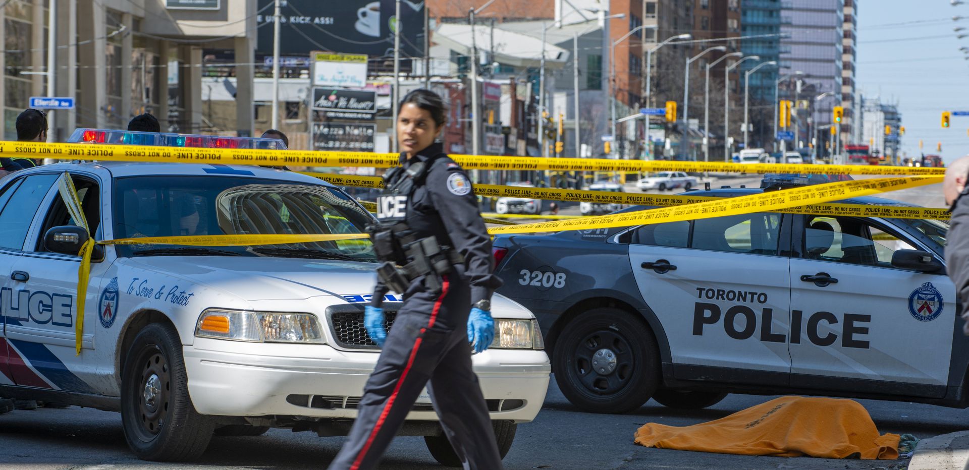 epa06687903 A covered body (R) lies on Yonge Street in northern Toronto, Canada, after a rented van drove along the sidewalk striking pedestrians on 23 April 2018. Eight to ten people were struck in two locations. Police took the driver into custody.  EPA/WARREN TODA