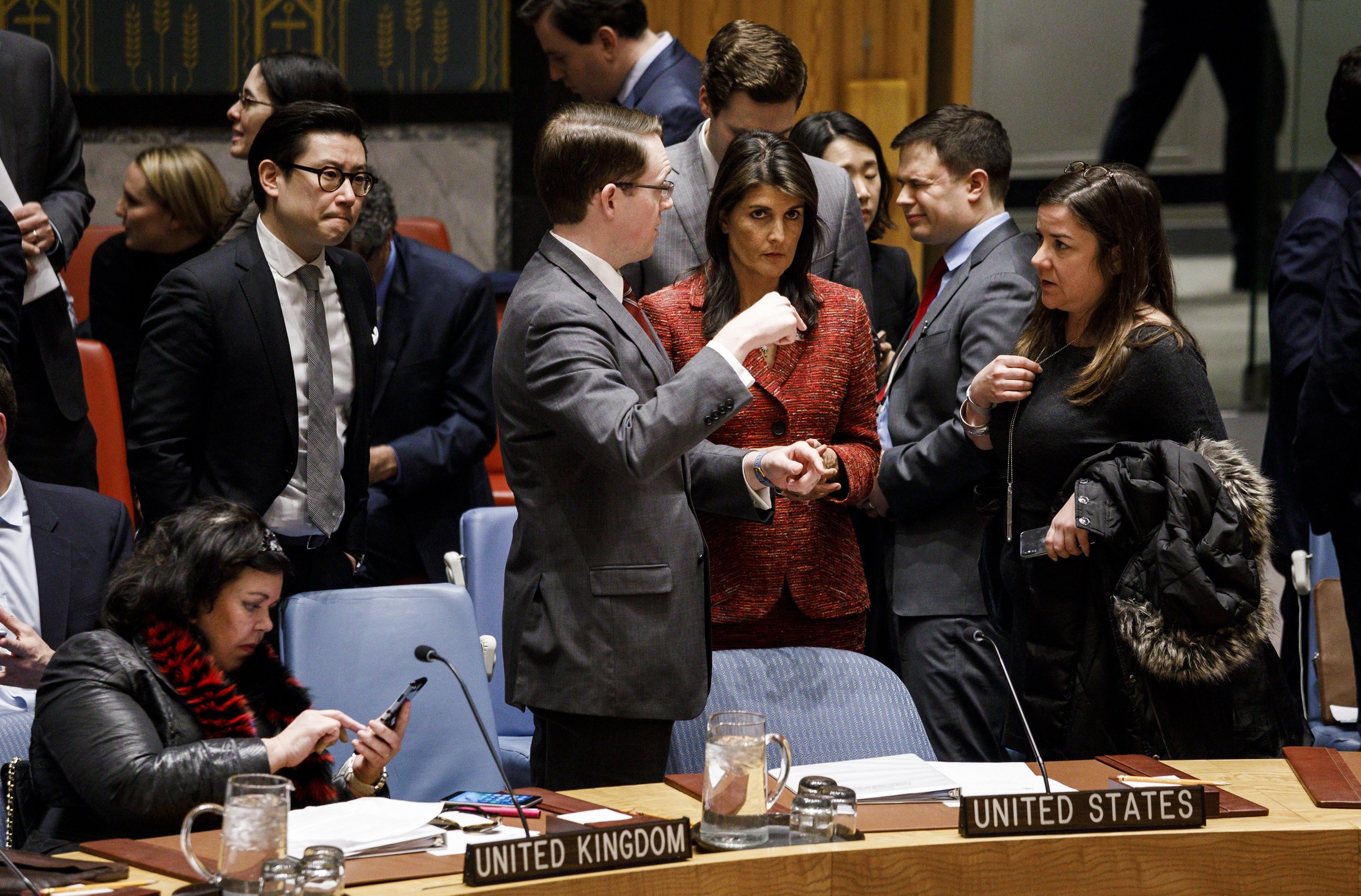 epa06660145 Nikki Haley (3-R), the United States' Permanent Representative to the United Nations, talks with staff and Karen Pierce (L), the United Kingdom's Permanent Representative to the United Nations, checks a message as diplomats gather to vote on United Nations Security Council draft resolutions in response to a suspected chemical weapons attack in Syria at United Nations headquarters in New York, New York, USA, 10 April 2018. The suspected chemical attack took place over weekend in the Damascus suburb of Douma, killing at least 49 people.  EPA/JUSTIN LANE