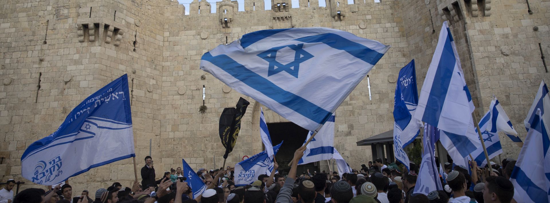 epa06733611 Israeli right wing activists wave flags at Damascus gate of Jerusalem's Old City, 13 May 2018. Israeli right wing activists are marking the 51st anniversary of the capture of east Jerusalem during the 1967 Six Day War, which many Israelis considers as the 'reunification' of Jerusalem, putting it all under Israeli control. The Palestinians still consider their part of the city, East Jerusalem, to be 'occupied'.  EPA/ATEF SAFADI