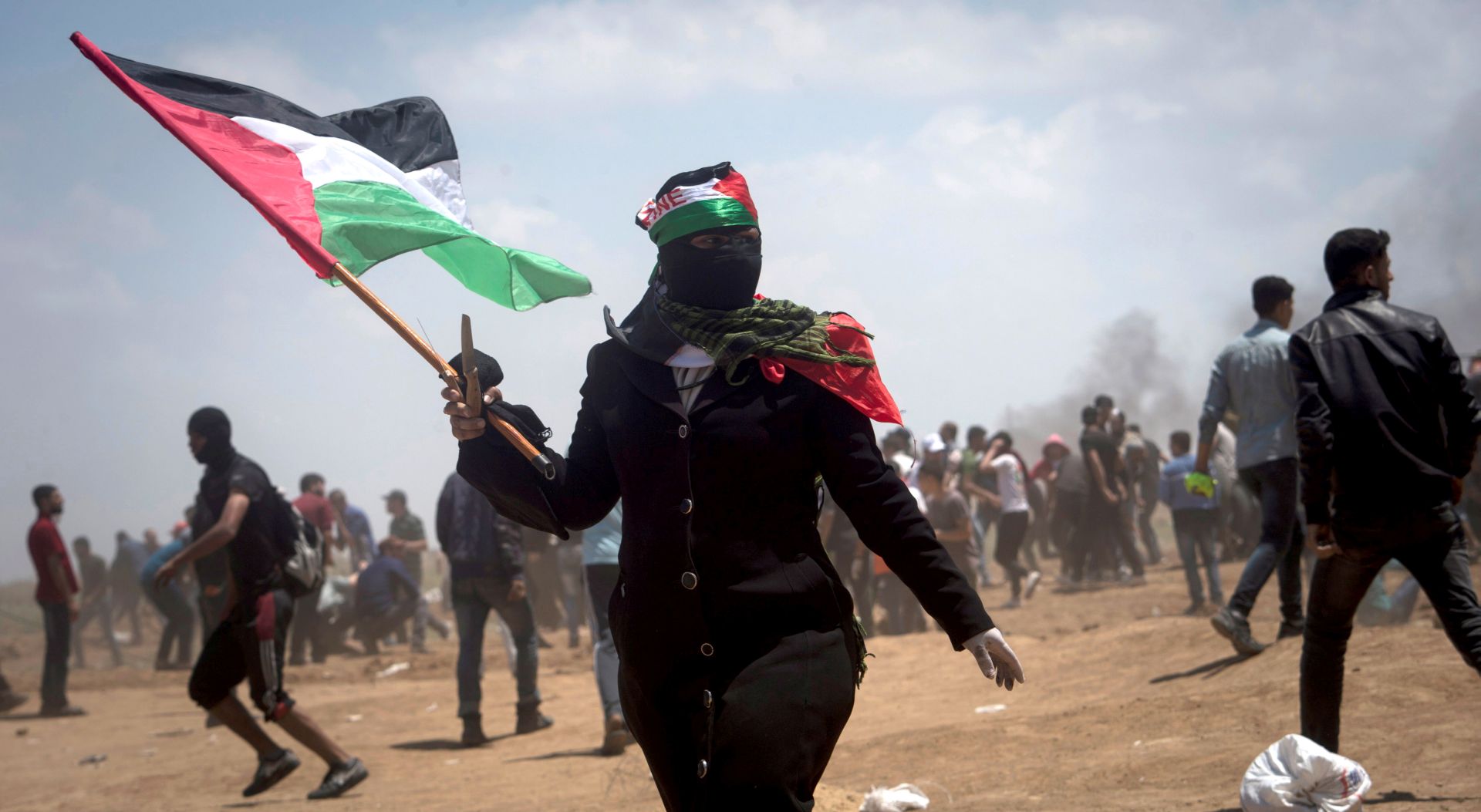 epa06735632 A Palestinian female demonstrator waves a Palestinian flag during a protest against the US Embassy move to Jerusalem and ahead of the 70th anniversary of Nakba, at the Gaza-Israeli border, in Abu Safia, Gaza Strip, 14 May 2018. According to media reports, at least 37 Palestinians were killed and more than 1600 wounded during clashes in Gaza-Israeli border during clashes against the US embassy move to Jerusalem as well as marking Nakba Day. Palestinians are marking the Nakba Day, or the day of the disaster, when more than 700 thousand Palestinians were forcefully expelled from their villages during the war that led to the creation of the state of Israel on 15 May 1948. Protesters call for the right of Palestinians to return to their homeland.  EPA/LUCA PIERGIOVANNI