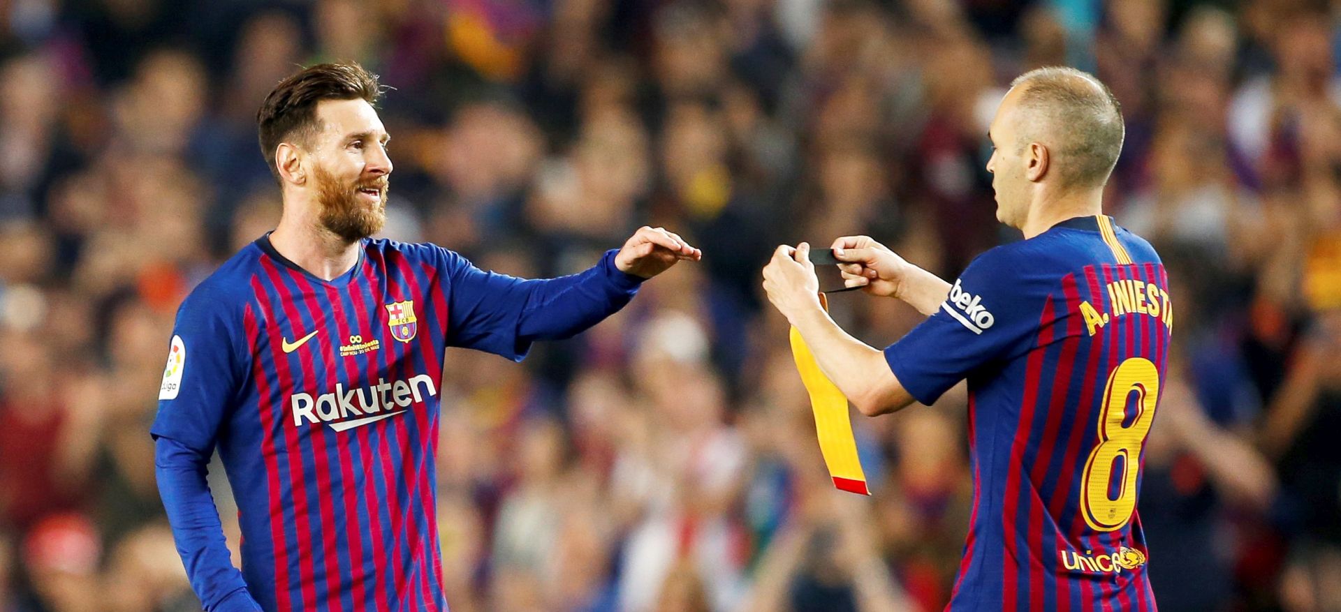 epa06753247 Barcelona's Andres Iniesta (R) hands the captain's armband to Lionel Messi (L) during the Primera Division Liga match held between Barcelona and Real Sociedad at Camp Nou stadium in Madrid, Spain, 20 May 2018. It is Iniesta's last match for Barcelona.  EPA/Enric Fontcuberta