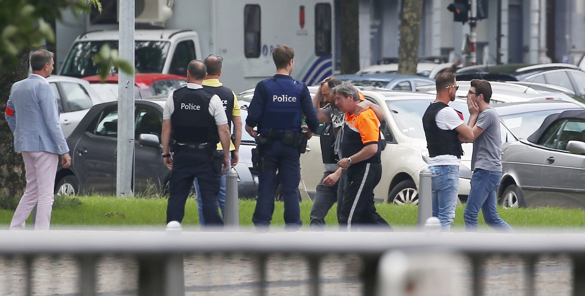 epa06770926 A man (4-R) is comforted by officials at the scene following a shooting in Liege, Belgium, 29 May 2018. According to media reports, a gunman was shot dead by anti-terrorist police after reportedly killing two police officers and a passerby and injuring two others in the center of the Belgian city of Liege on 29 May. During a shootout the man was said to have entered a high school where he took hostage a female cleaner before being shot by the police. Authorities are investigating the incident and terrorism was not ruled out as a possible motive.  EPA/JULIEN WARNAND