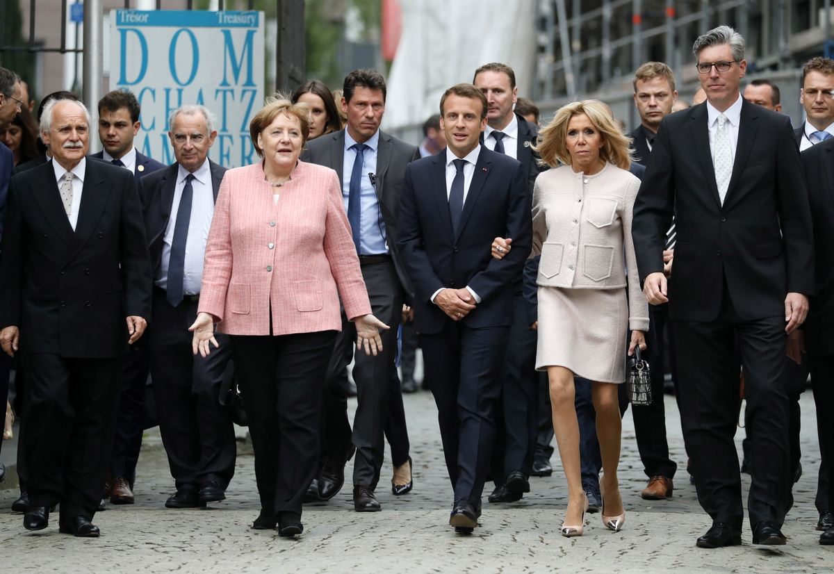 epa06724506 German Chancellor Angela Merkel (C-L), French President Emmanuel Macron (C) and his wife Brigitte Macron (C-R) arrive for the Charlemagne Prize ceremony at the Cathedral in Aachen, Germany, 10 May 2018. Macron was named to receive the prestigious Charlemagne Prize on 10 May 2018. Annually since 1950, the 'Karlspreis' has been awarded to people who contributed to the unity of Europe and is given by the German city of Aachen.  EPA/RONALD WITTEK
