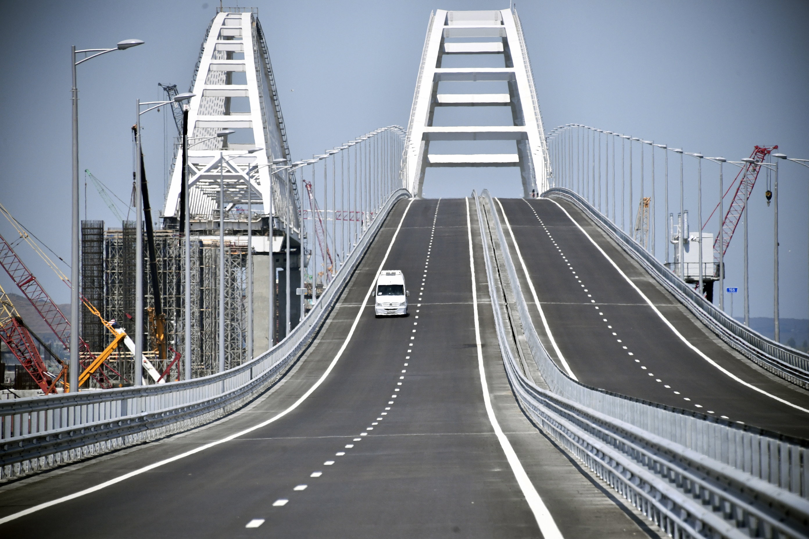epa06737904 A car drives on the Krymsky (Crimean) Bridge over the Kerch Strait 15 May 2018, prior to its opening ceremony. The 19-kilometers-long road-and-rail bridge connects the Crimean peninsula,  annexed by Russia from Ukraine in March 2014, with the Taman Peninsula of the Russian mainland. Public transport and automobiles traffic on Crimean Bridge will be launched in early hours of 16 May 2018.  EPA/ALEXANDER NEMENOV / POOL
