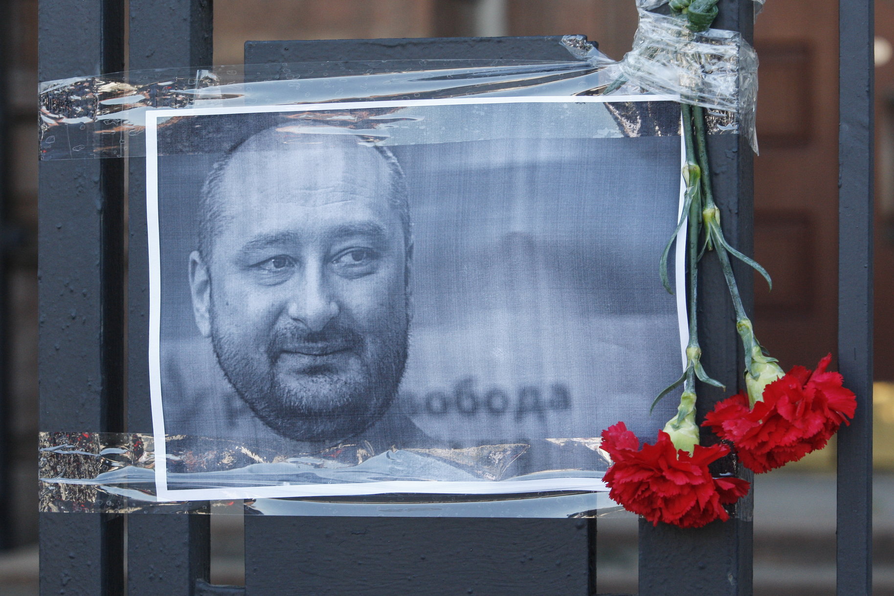 epa06772534 The Russian opposition journalist Arkady Babchenko portrait is seen on a fence of Russian embassy in Kiev, Ukraine, 30 May 2018. Russian opposition journalist Arkadiy Babchenko, who lived in Ukraine, was shot on 29 May 2018 in his Kiev home by three shots to his back and died from his wounds on the way to hospital, local media report. Babchenko was criticizing Russian authorities and writing about arrests of Crimean-Tatarian journalists in the Crimea after annexation of it by Russia.  EPA/STEPAN FRANKO