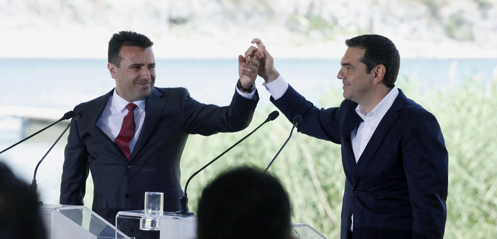 epa06814944 Greek Prime Minister Alexis Tsipras (R) and FYROM Prime Minister Zoran Zaev (L) join their hands in the village of Psarades, Florina, Greece, 17 June 2018. The foreign ministers of Greece and the Former Yugoslav Republic of Macedonia (FYROM), Nikos Kotzias and Nikola Dimitrov, and the UN Secretary General's Special Envoy for the name dispute signed a historic agreement on 17 June 2018 for resolving the decades-long issue during a lakeside signing ceremony in Prespes, where the borders of Greece, FYROM and Albania meet.  EPA/NIKOS ARVANITIDIS