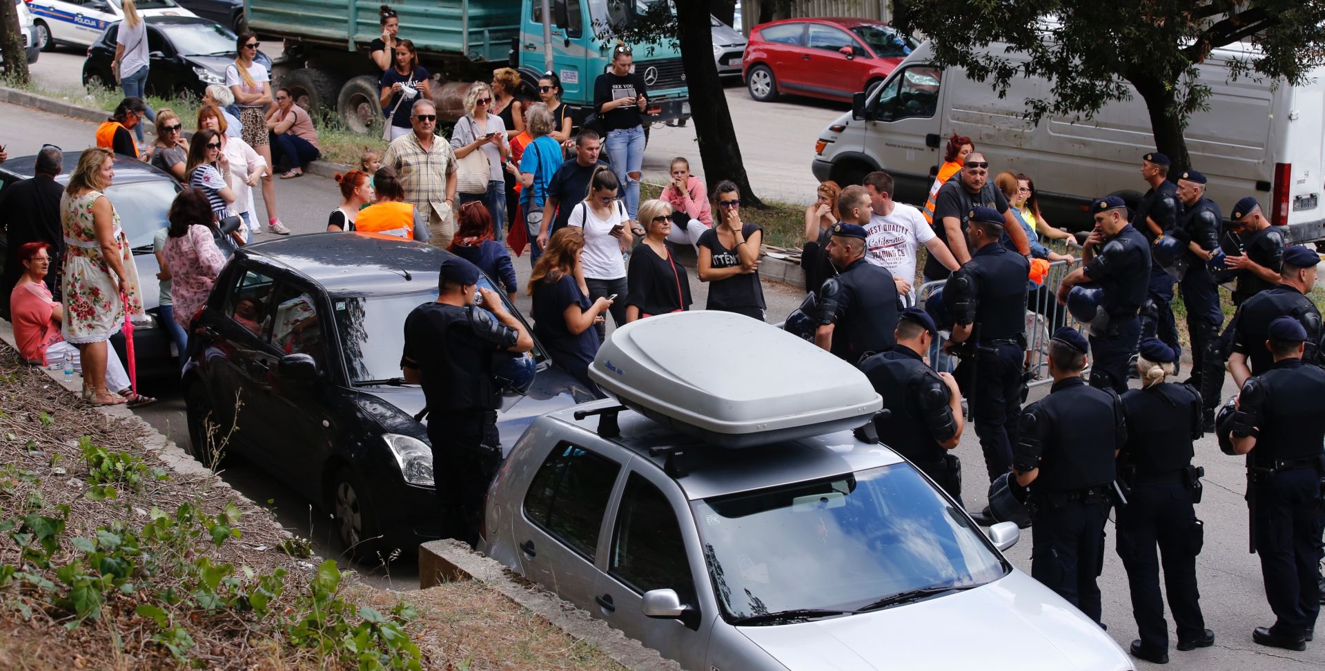 Split, 19.06.2018. - Na splitskim Pujankama se održava ovrha nad osmogodišnjim Cesareom Avenatijem kojega se po sudskoj odluci treba predati ocu Alessandru. Stotinjak metara od ulaza u zgradu skupili su se građani koji prosvjedom pokušavaju zaustaviti izvršenje ovrhe. Na terenu je velik broj policijskih službenika i vozila koji osiguravaju prostor.
foto HINA/ Miroslav LELAS/ lm