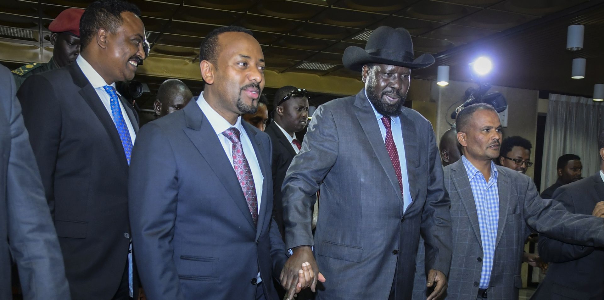 epa06825544 South Sudanese President Salva Kiir (2-R) and Ethiopian Prime Minister Abiy Ahmed (2-L) holds each other's hand as they walk together prior to their meeting in Addis Ababa, Ethiopia, 20 June 2018. Kiir and his rival and the rebel leader Riek Machar are in Ethiopia to hold talks at the invitation of Ahmed in an effort to end their five-year civil war that killed tens of thousands and displaced millions.  EPA/STRINGER