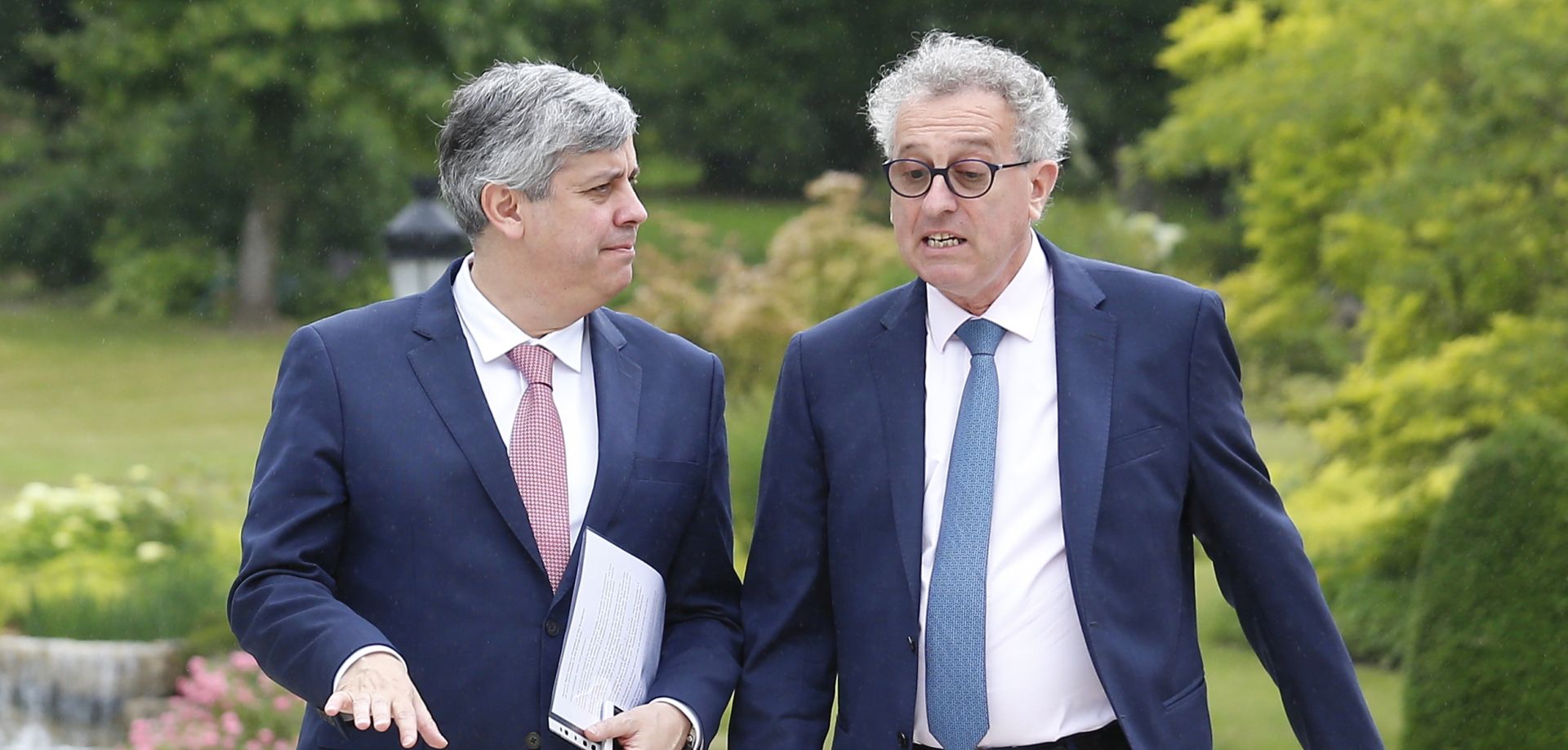 epa06827233 The President of the Eurogroup, Portuguese Finance Minister Mario Centeno (L) and Luxembourg's Finance Minister Pierre Gramegna (R), during a meeting for the 20th anniversary of Eurogroup at Castle of Senningen in Luxembourg, 21 June 2018. The Eurogroup will assess the progress achieved by Greece in implementing the prior actions required under the fourth (and the final) review of its programme.  EPA/JULIEN WARNAND