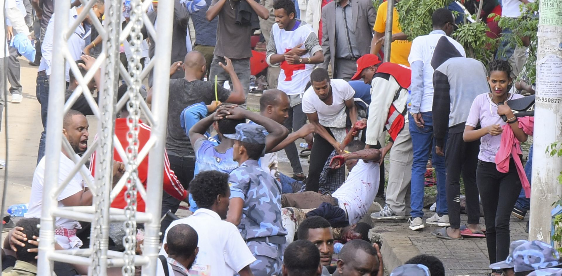epa06832540 An injured man is helped by others as security officers gather at the scene of an explosion during a massive rally to support the countryâ€™s new reformist prime minister Abiy Ahmed in Meskel Square in Addis Ababa, Ethiopia, 23 June 2018. Reports say the blast occurred shortly after Abiy addressed thousands of his supporters. Abiy, who addressed the crowd after the blast, says a few people have been killed.  EPA/STR