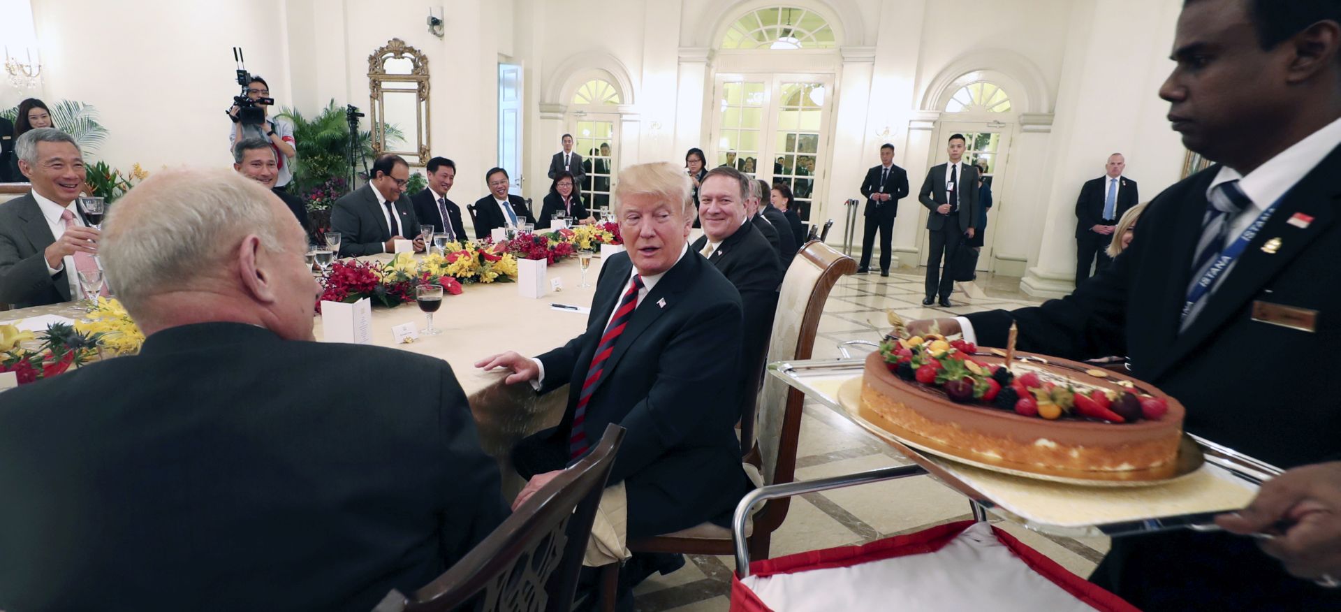 epa06799983 A handout photo made available by the Ministry of Communications and Information of Singapore shows US President Donald J. Trump (C) being presented with a birthday cake while Singapore's Prime Minister Lee Hsien Loong (back L) claps during a working lunch at the Istana in Singapore, 11 June 2018. US President Donald J. Trump and North Korean leader Kim Jong-un are scheduled to meet at the Capella Hotel on Singapore's Sentosa Island for an historic summit on 12 June 2018.  EPA/MCI SINGAPORE / HANDOUT  HANDOUT EDITORIAL USE ONLY/NO SALES