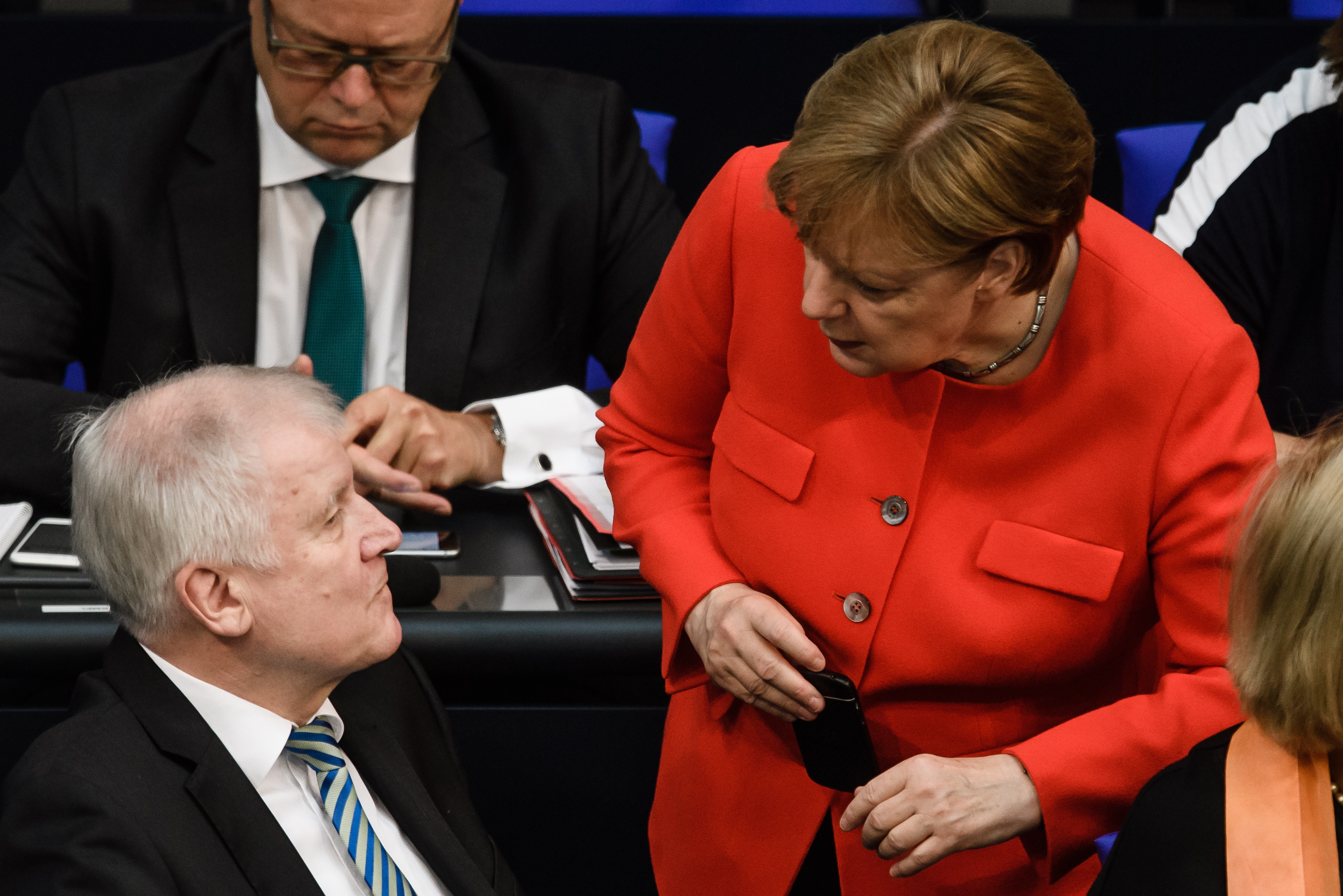 epa06864944 German Chancellor and Christian Democratic Union (CDU) party leader Angela Merkel (R) and German Minister of Interior, Construction and Homeland and chairman of the German Christian Social Union (CSU) Horst Seehofer (L) talk during a session at the German parliament 'Bundestag' in Berlin, Germany, 05 July 2018. The 'Bundestag' will discuss, amongst others, the budget recommendations for inner politics, construction, homeland security and freedom of information.  EPA/CLEMENS BILAN