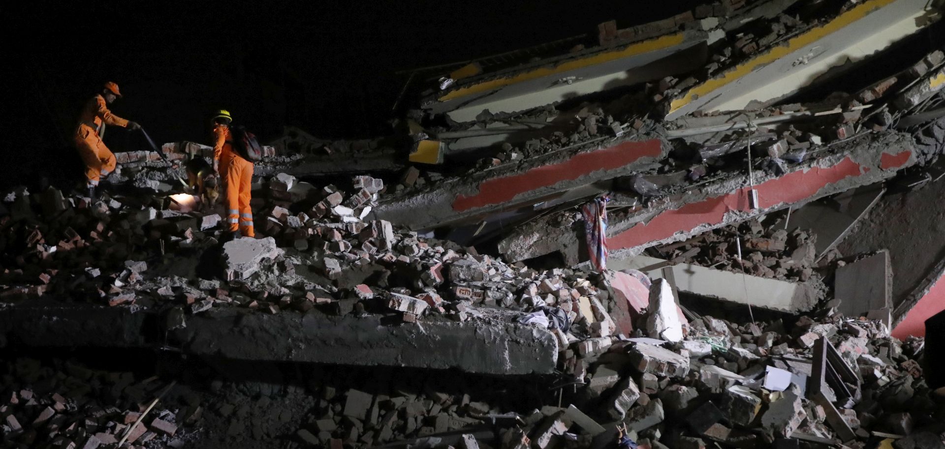 epa06895561 Indian National Disaster Response Force (NDRF) rescue workers operating on the site of a building collapse at Greater Noida, Uttar Pradesh, India, early morning 18 July 2018.  According to the news reports the incident took place in Shah Beri village and two bodies were recovered and fifty people are feared trapped.  EPA/HARISH TYAGI