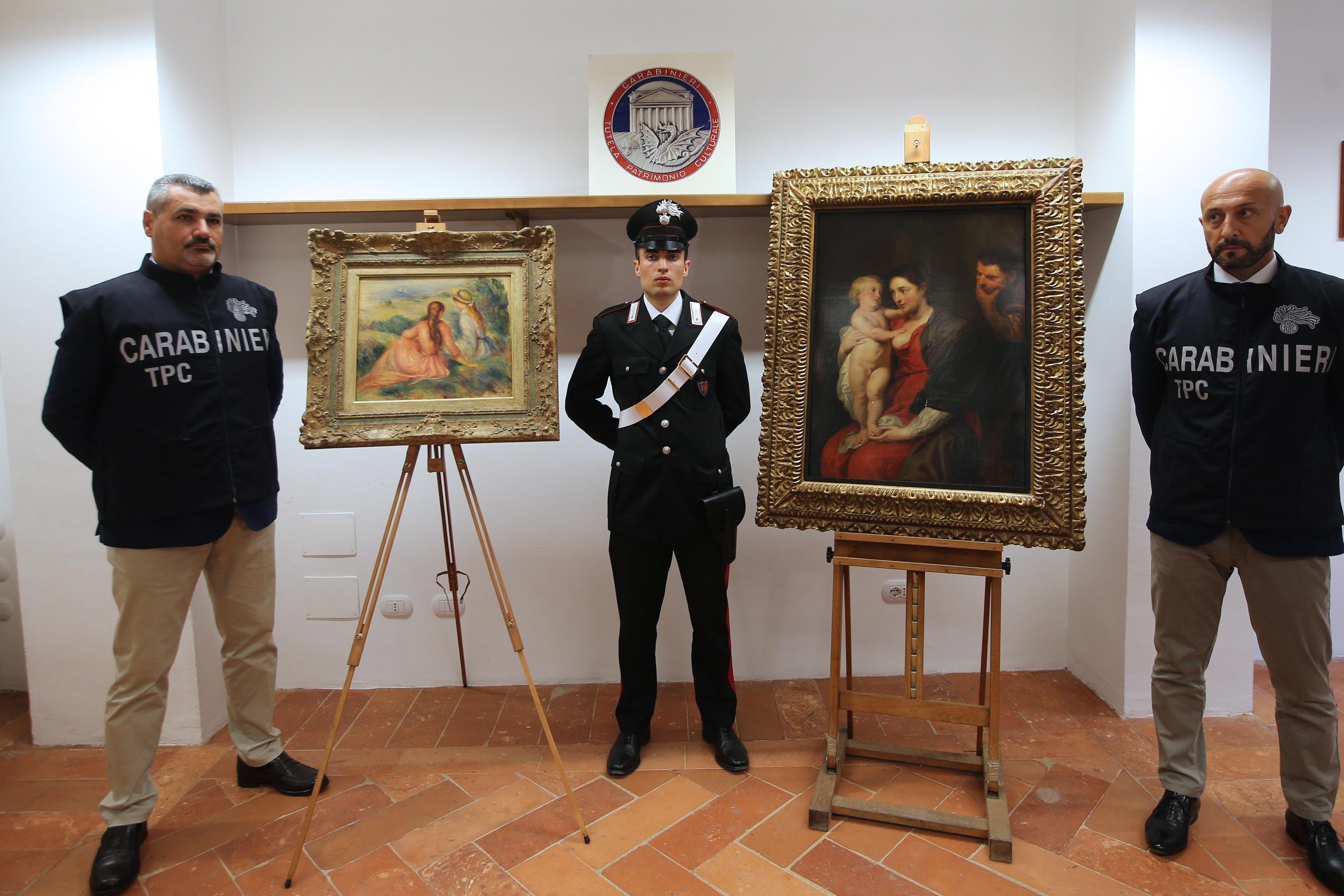 epa06900302 Italian carabinieri pose near the paintings 'Le fanciulle sul prato' by Renoir (L) and 'La Sacra Famiglia' by Rubens (R) during a press conference in Monza, Italy, 20 July 2018. The two paintings were stolen from two gallery owners on 20 April 2017 in Monza and were recently found in a private warehouse in Turin.  EPA/FABRIZIO RADAELLI