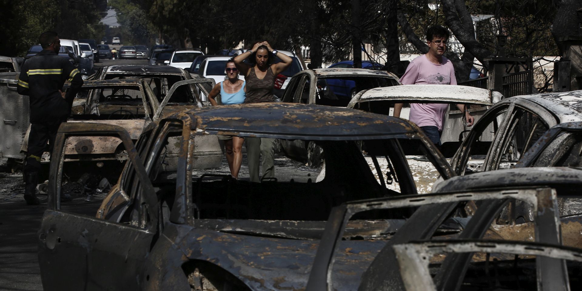 epa06907188 Residents react as they look at burned cars following a forest fire in Mati a northeast suburb of Athens, Greece, 24 July 2018. At least 50 people have lost their lives in wildfires that broke out in eastern Attica while there are fears of even more casualties, as many telephone calls have been made to the Fire Brigade to report missing persons. Hundreds of firefighters are battling the fires as regional Greek authorities declared a state of emergency in the Attica region, in the eastern and western parts of greater Athens, media reported.  EPA/YANNIS KOLESIDIS