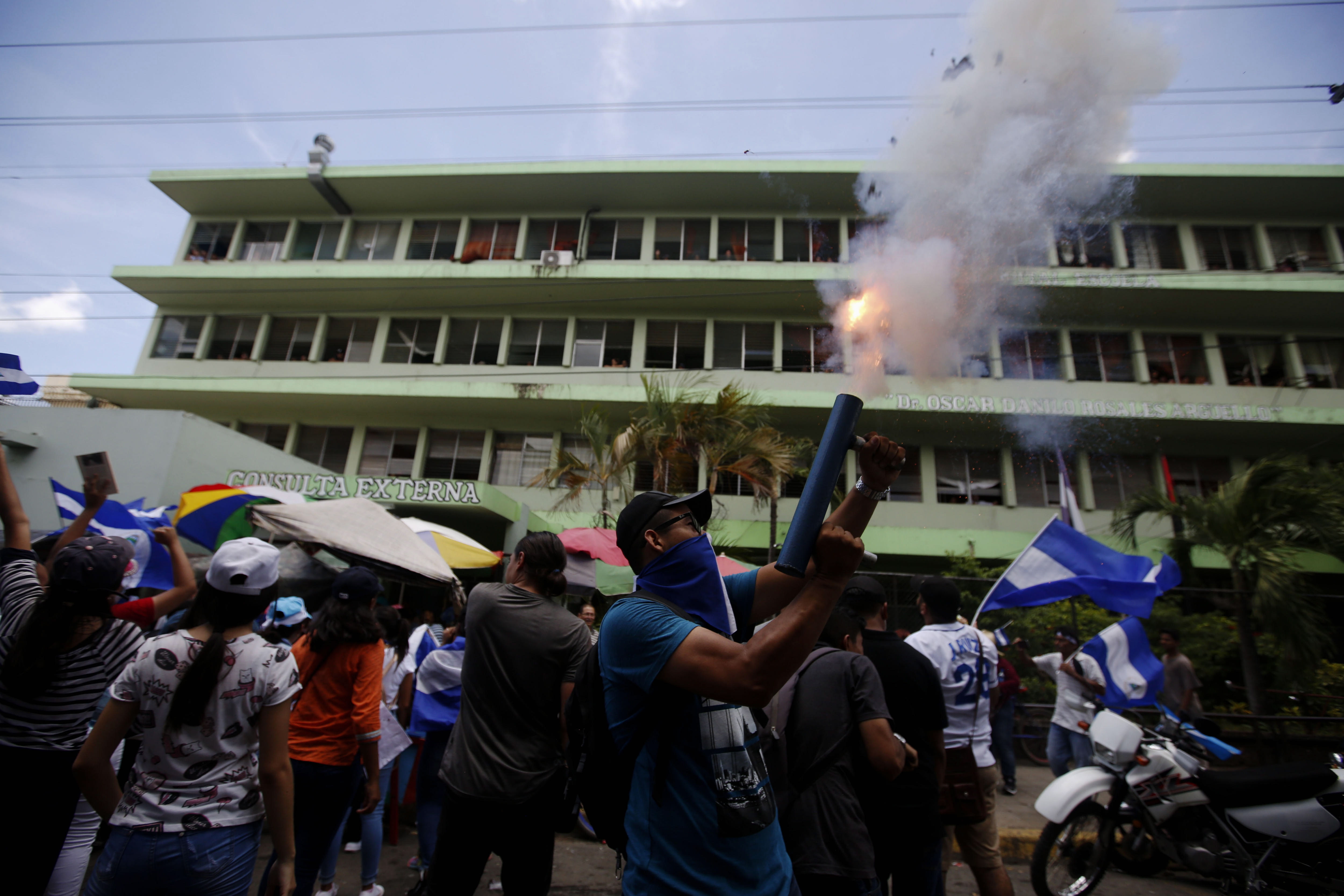 epa06919555 A man shoots a mortar in front of a hospital during a protest against Daniel Ortega's Government, in Leon, Nicaragua, 30 July 2018. Students marched against the taking over of universities by the government and stating they refused to attend lectures until the president resigns.  EPA/Esteban Biba