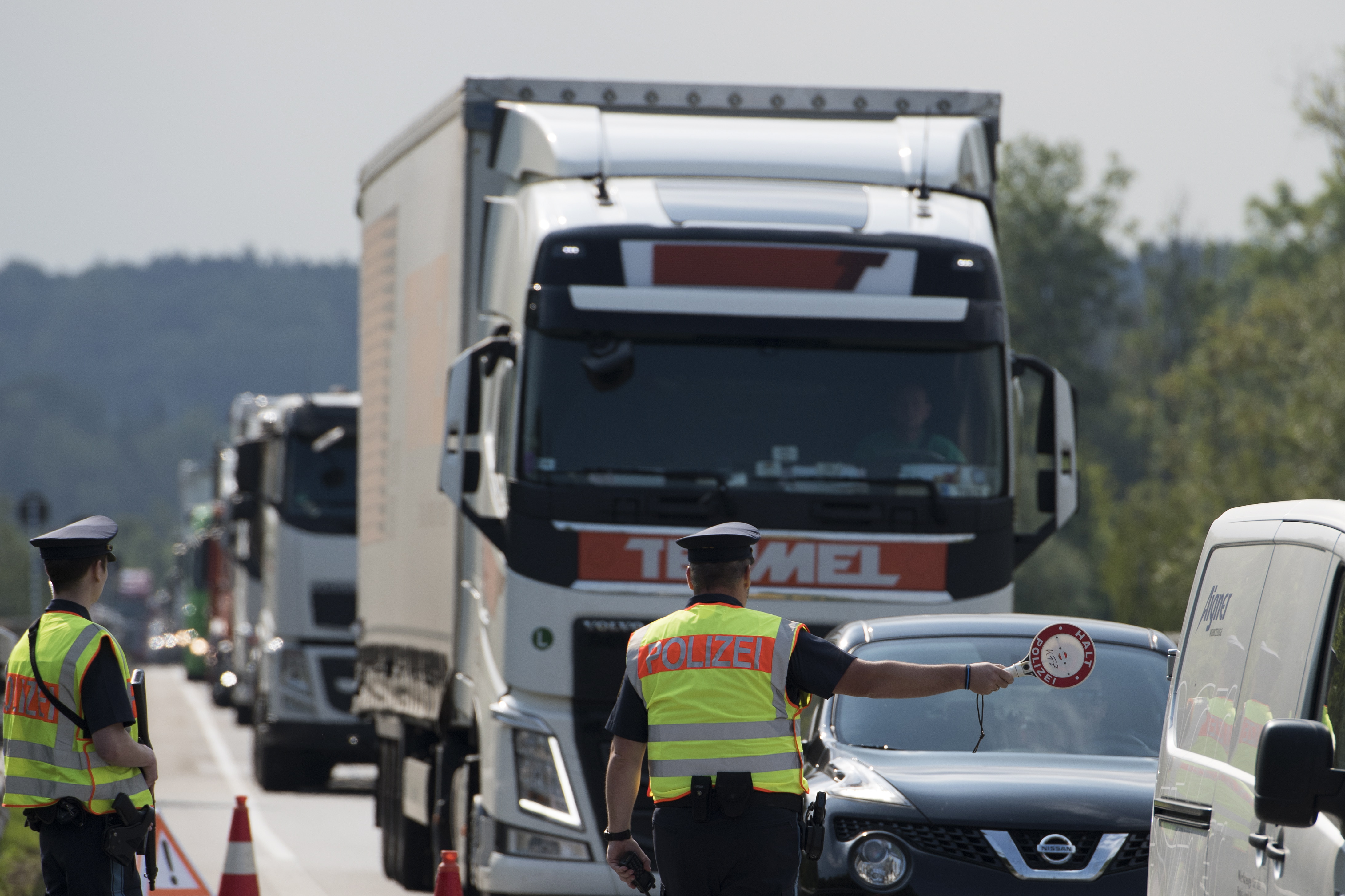 epa06896048 Police officers check cars and trucks during a border inspection post at the German border to Austria in Kirchdorf am Inn, Bavaria, Germany, 18 July 2018. The Bavarian Border Police is a police headquarters newly founded in 2018, the state police in the border area will search for criminals in coordination with the federal police.  EPA/ANDREAS SCHAAD