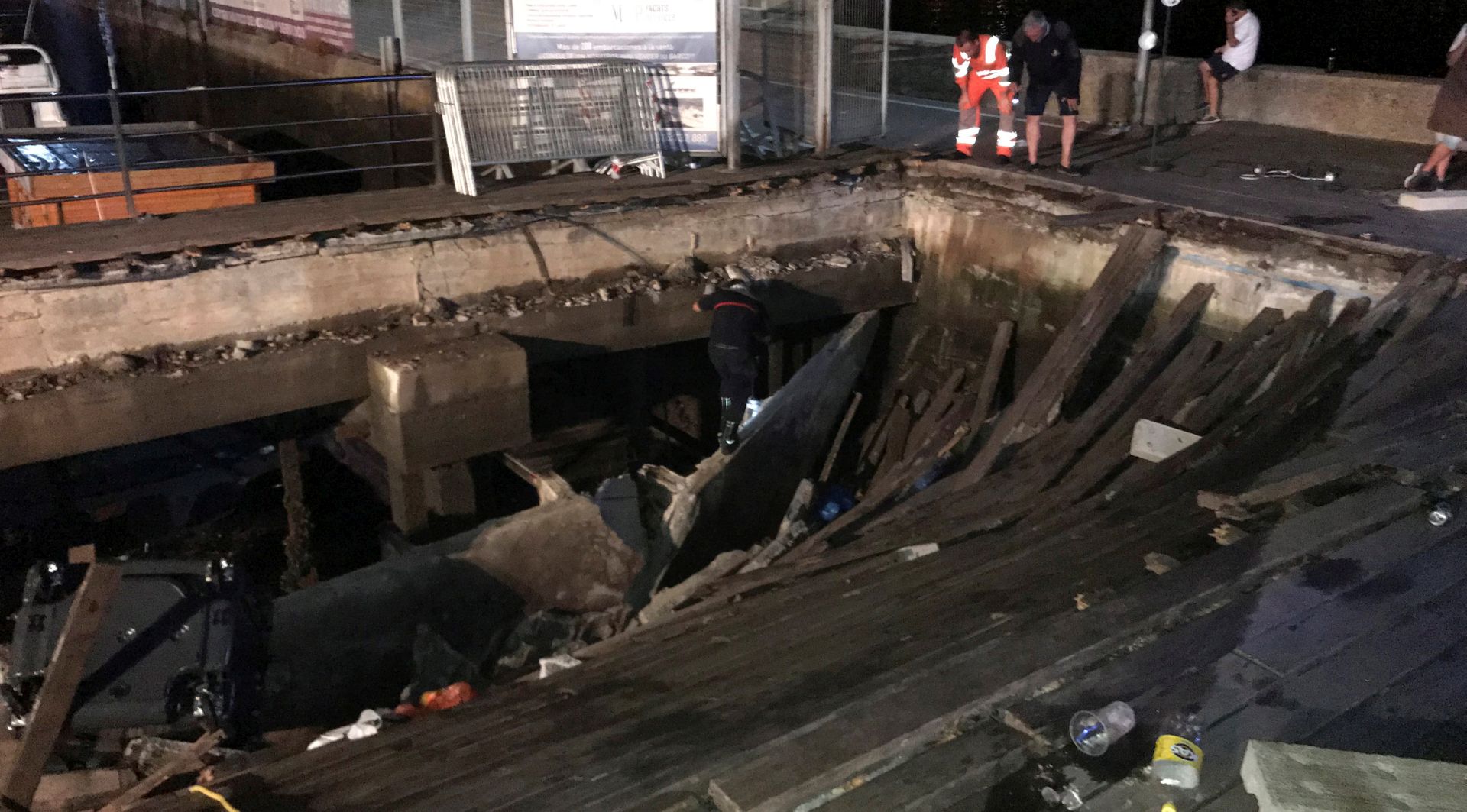 epa06947435 Several firefighters search for victims after several dozens people fell into the sea when a wooden gateway collapsed during a concert in Vigo, northwestern Spain, late night 12 August 2018. Some 266 people were wounded, five of them are seriously injured, in the accident happened during a music concert held as part of O Marisquino Festival.  EPA/Sxenick