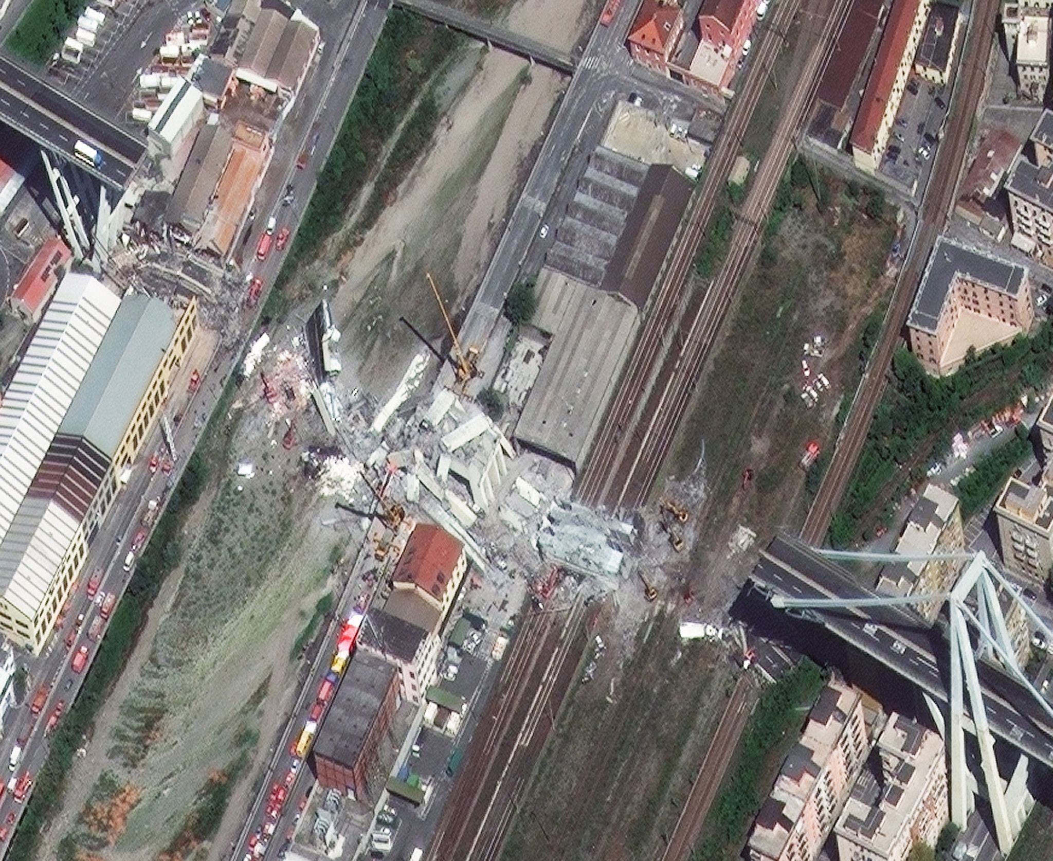 epa06952303 A handout photo made available by the European Space Imaging on 16 August 2018 shows a satellite image of the collapsed section of the Morandi Bridge in Genoa, northern Italy, 15 August 2018. The bridge, a viaduct on the A10 motorway in Genoa and one of the major links to France, collapsed on 14 August 2018, killing at least 39 people and injuring at least 15 others, authorities said. In response to the disaster, Italian Prime Minister Giuseppe Conte has declared a 12-month state of emergency in the region of Liguria, as search and rescue teams are still working to find survivors in the rubble, with dozens of people reportedly missing.  EPA/EUROPEAN SPACE IMAGING HANDOUT -- BEST QUALITY AVAILABLE -- HANDOUT EDITORIAL USE ONLY/NO SALES