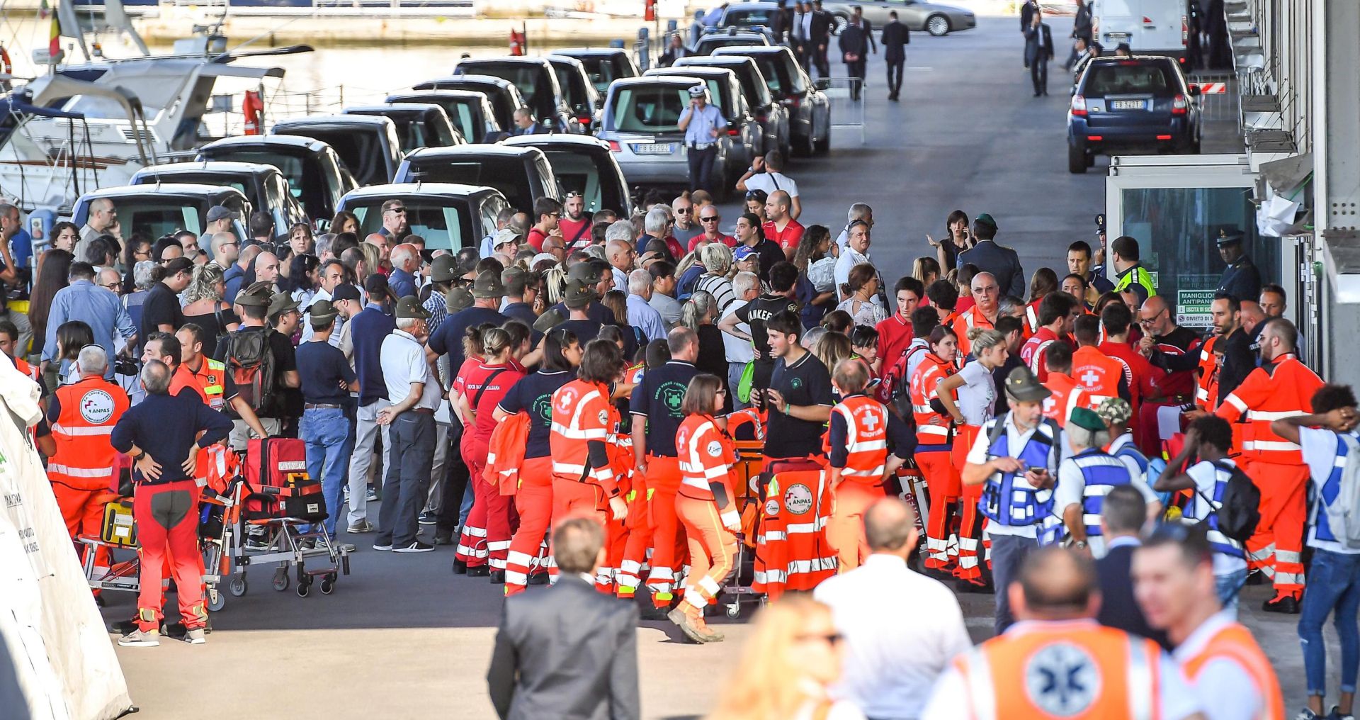 epa06955410 People gather outside the Fair of Genoa to attend State funerals of the victims of Morandi highway bridge collapse in Genoa, Italy, 18 August 2018. The Morandi bridge partially collapsed on 14 August, killing at least 41 people.  EPA/SIMONE ARVEDA