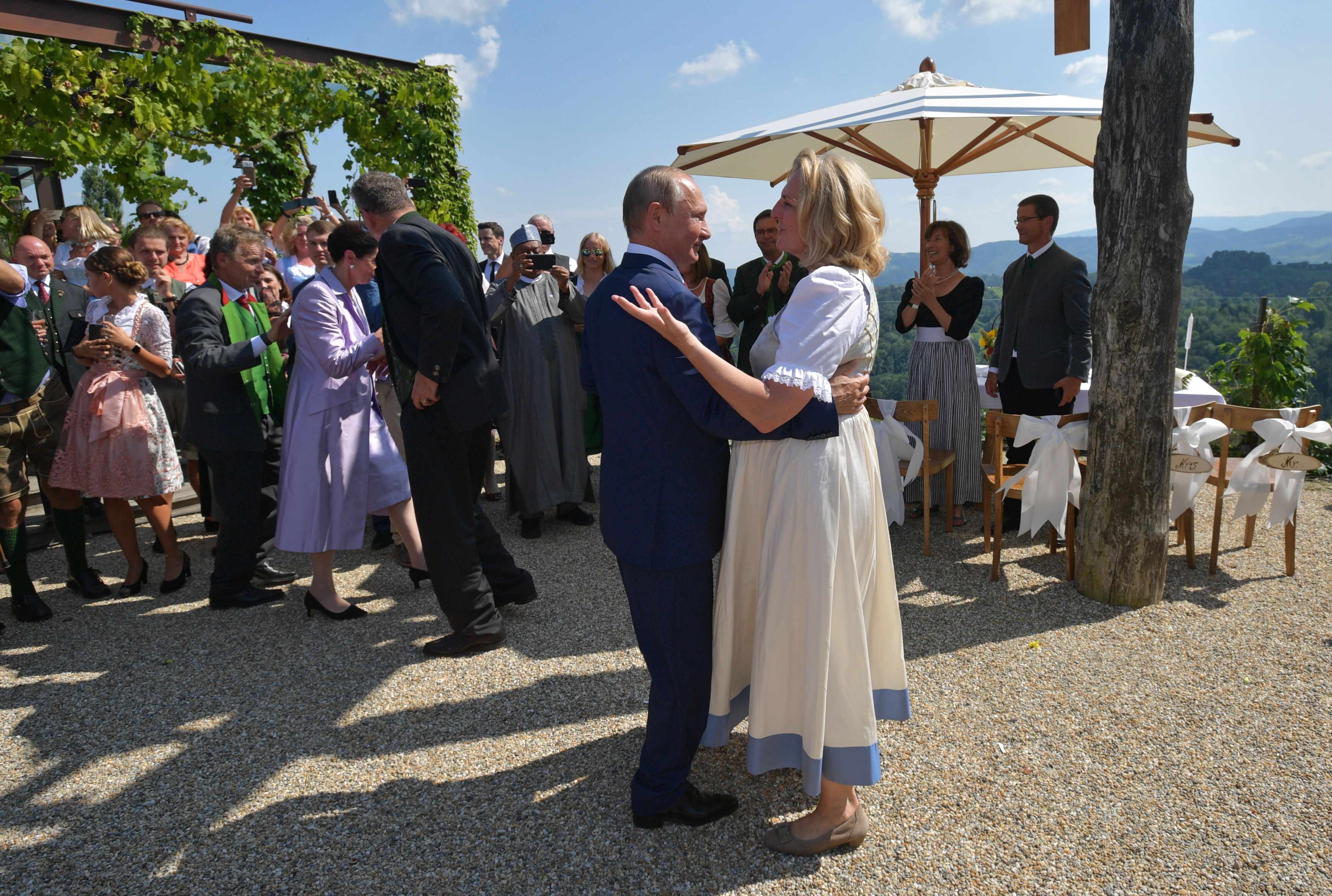 epa06957056 Russian President Vladimir Putin (C-L) dances with Austrian Foreign Minister Karin Kneissl (C-R) during her wedding to Austrian businessman Wolfgang Meilinger in Gamlitz, Austria, 18 August 2018. According to reports, Putin attended Kneissl's wedding in the Styrian municipality of Gamlitz on 18 August, before travelling to Meseberg, Germany, where he is to meet with German Chancellor Angela Merkel.  EPA/ALEXEI DRUZHININ / SPUTNIK / KREMLIN POOL