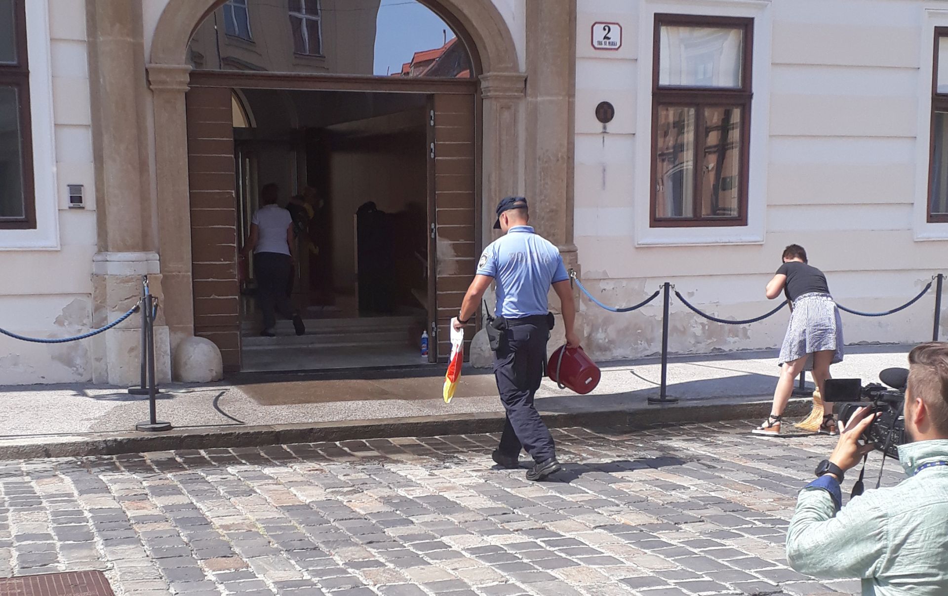Zagreb, 21.8.2018.- Novinarka Iva Anzuloviæ u utorak je bacila kantu punu izmeta pred ulaz u Banske dvore. Imala je majicu na kojoj je slika pokojnog vukovarskog novinara Sinie Glavaeviæa i natpis "Optuujem vas, gospodo". Odmah je pristupila policija, zatraila i dobila osobnu iskaznicu te je odvela u zgradu Vladu, u kojoj se jo nalazi.
foto HINA/ Magdalena LINDE/ ua