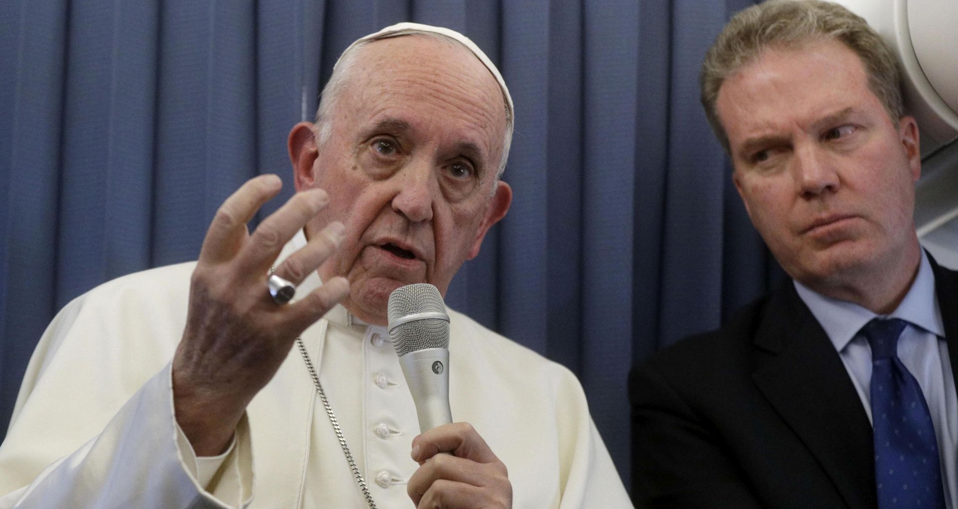 epa06975486 Pope Francis (L), flanked by Vatican spokesperson Greg Burke (R), listens to a journalist's question during a press conference aboard the flight to Rome at the end of his two-day visit to Ireland, 26 August 2018. The pontiff was in Ireland on 25 and 26 August 2018 to attend the World Meeting of Families (WMOF) 2018.  EPA/GREGORIO BORGIA / POOL