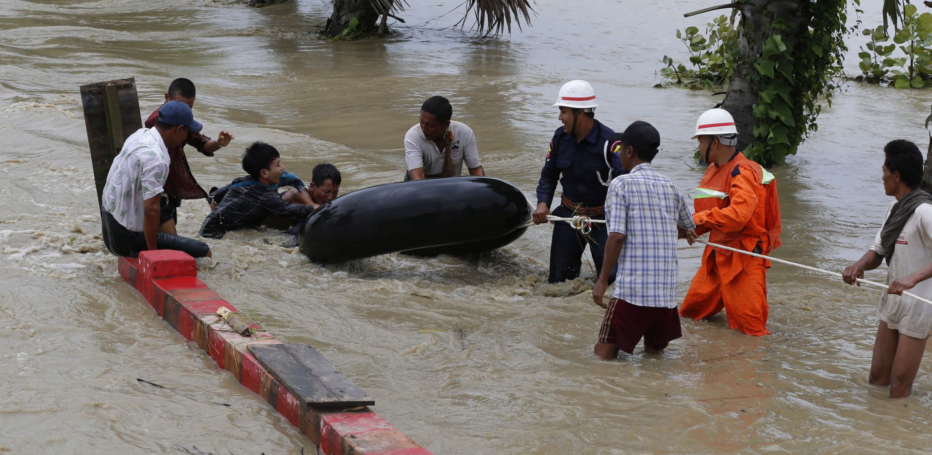epa06980725 Residents walk at a flooded road due to ramping waters from Swar Chaung dam, at Yedashe city, Bago Region, near Naypyitaw, Myanmar, 29 August 2018. Flood affected the villages from Swar township, Bago region (about 260km on Yangon-Naypyitaw highway road) caused by the damage of the water diversion from Swar creek dam. About four hundred houses from the villages have been affected by the flood and bridge near the 260km of Yangon-Naypyitaw highway road has damage in some part. Yangon-Naypyitaw highway road is temporary close by authority, according to the information ministry. No casualities or injured has been reported.  EPA/HEIN HTET