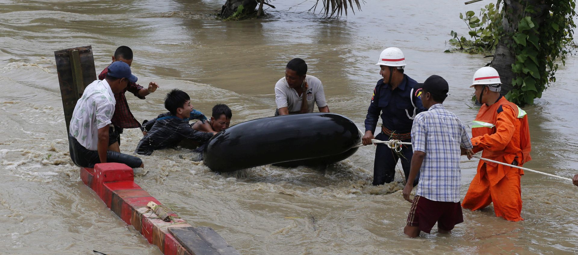 epa06980725 Residents walk at a flooded road due to ramping waters from Swar Chaung dam, at Yedashe city, Bago Region, near Naypyitaw, Myanmar, 29 August 2018. Flood affected the villages from Swar township, Bago region (about 260km on Yangon-Naypyitaw highway road) caused by the damage of the water diversion from Swar creek dam. About four hundred houses from the villages have been affected by the flood and bridge near the 260km of Yangon-Naypyitaw highway road has damage in some part. Yangon-Naypyitaw highway road is temporary close by authority, according to the information ministry. No casualities or injured has been reported.  EPA/HEIN HTET