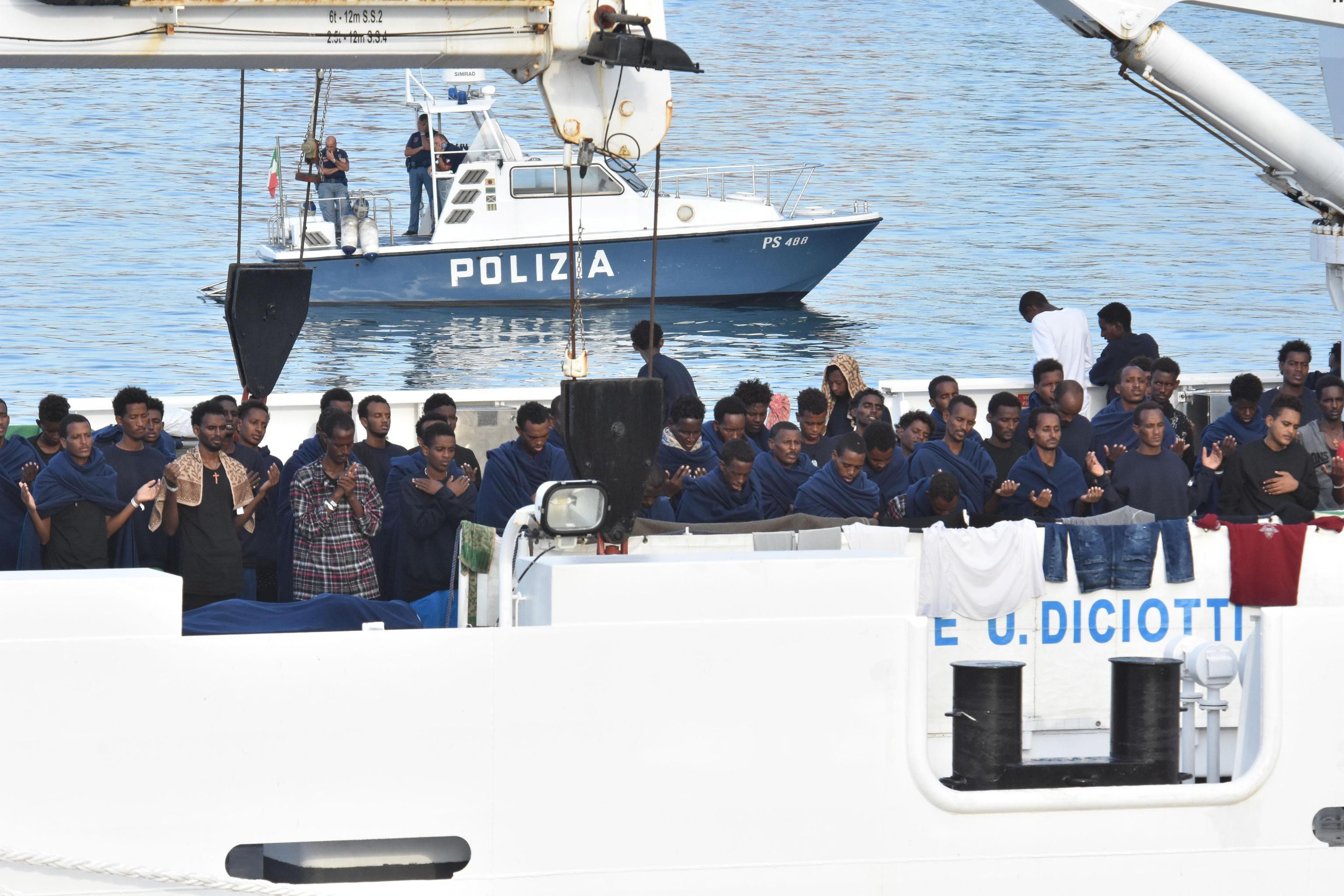 epa06963783 Migrants pray as they wait to disembark from Italian Coast Guard ship Diciotti in the port of Catania, Italy, 22 August 2018. Italian Interior Minister Matteo Salvini said on 20 August the rescued migrants are only allowed to disembark if the European Union member states agree to take in some of them. The ship entered on 20 August in the port of Catania with the 177 migrants rescued from a barge off Lampedusa island.  EPA/ORIETTA SCARDINO