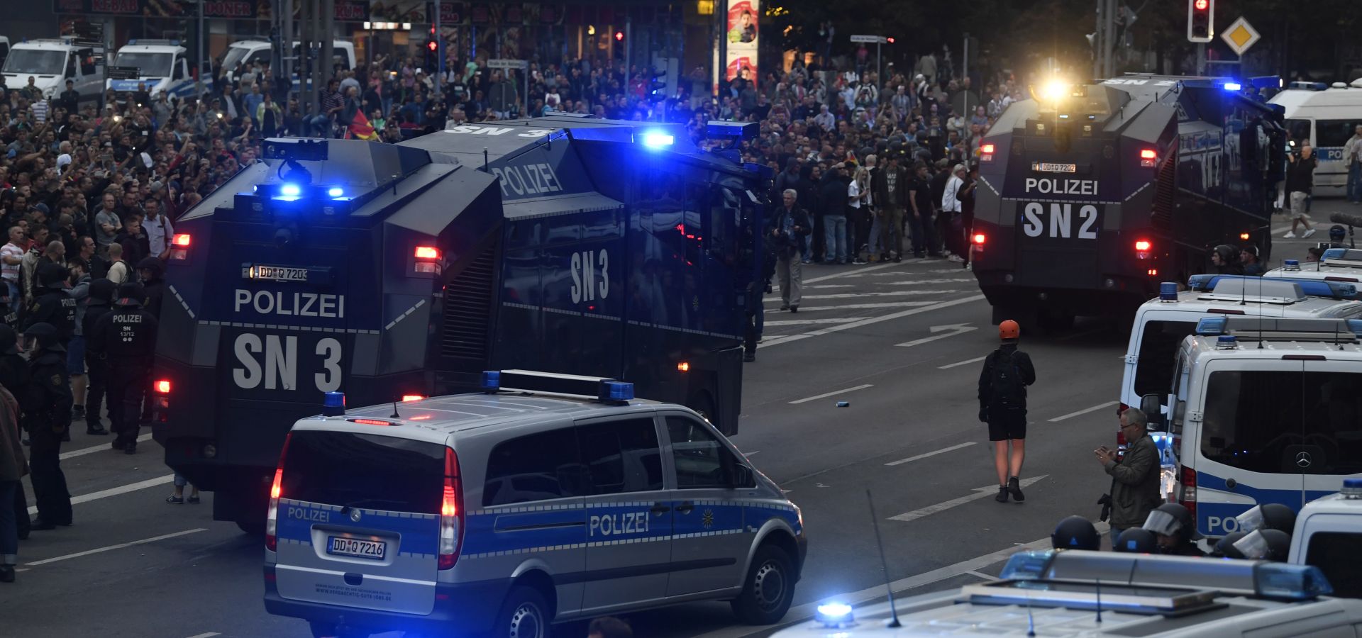 epa06977032 Police water cannon vehicle approaching right wing protesters as they gather at the place where a man was stabbed in the night of the 25 August 2018, in East German city Chemnitz, Germany, 27 August 2018. A 35-year-old man reportedly was stabbed and died shortly after what police described as a 'scuffle between members of different nationalities' at a city festival. The incident kept police and the city government busy since then as there were several spontaneous marches of hundreds of right-wing supporters in Chemnitz.  EPA/FILIP SINGER