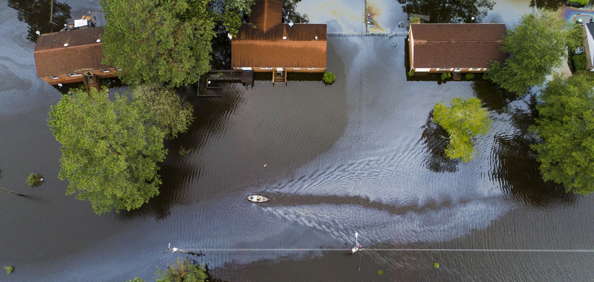 epa07023451 Two people in a canoe paddle through a street that was flooded by Hurricane Florence north of New Bern, North Carolina USA, 15 September 2018. Storm surge and heavy flooding from the hurricane has inundated much of Eastern North Carolina. Florence has been downgraded to a tropical storm but is still expected to bring a storm surge with heavy flooding to the Carolinas.  EPA/JIM LO SCALZO