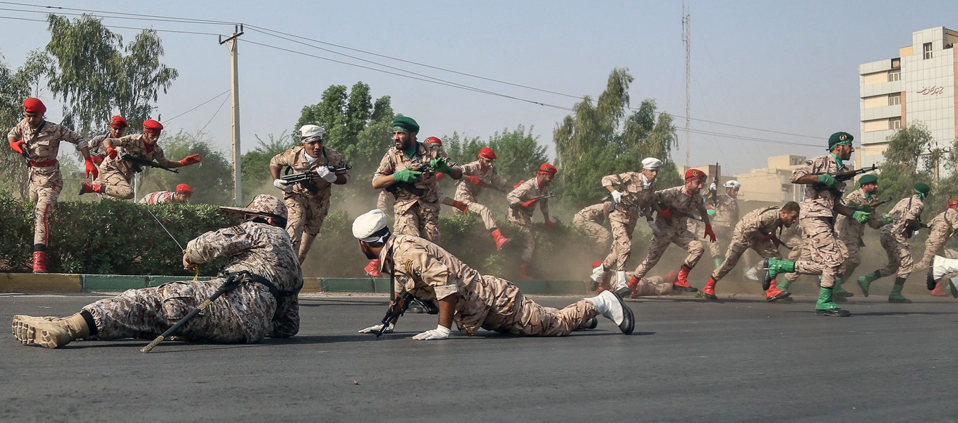 epa07039277 Iranian soldiers jump over a hedge at a street as they run for cover during a terror attack that occurred during a military parade in the city of Ahvaz, southwest Iran, 22 September 2018. According to media reports, gunmen have opened fire during an Iranian military parade in the south-western city of Ahvaz, killing at least 25 people, including civilians, and injuring dozens.  EPA/MORTEZA JABERIAN