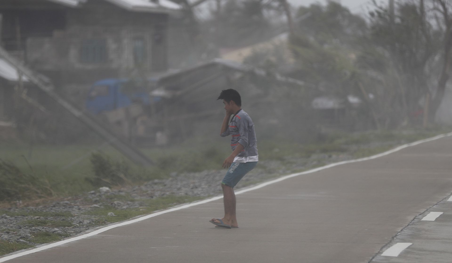 epa07022715 Strong winds batters a villager in the typhoon-hit town of Baggao, Cagayan province, Philippines, 15 September 2018. Mangkhut, the most powerful typhoon to hit the Philippines in the last five years, has weakened slightly after its passage through the northern part of the country, with sustained winds of 170 kilometers per hour and gusts of up to 260 kilometers per hour without any  reports of casualties so far, authorities said. Over 50,000 people in all regions expected to be struck by the typhoon have been evacuated although over 5.2 million Filipinos living in a 125 kilometer radius from Mangkhut's trajectory will feel its impact, according to the National Disaster Risk Reduction and Management Council.  EPA/FRANCIS R. MALASIG