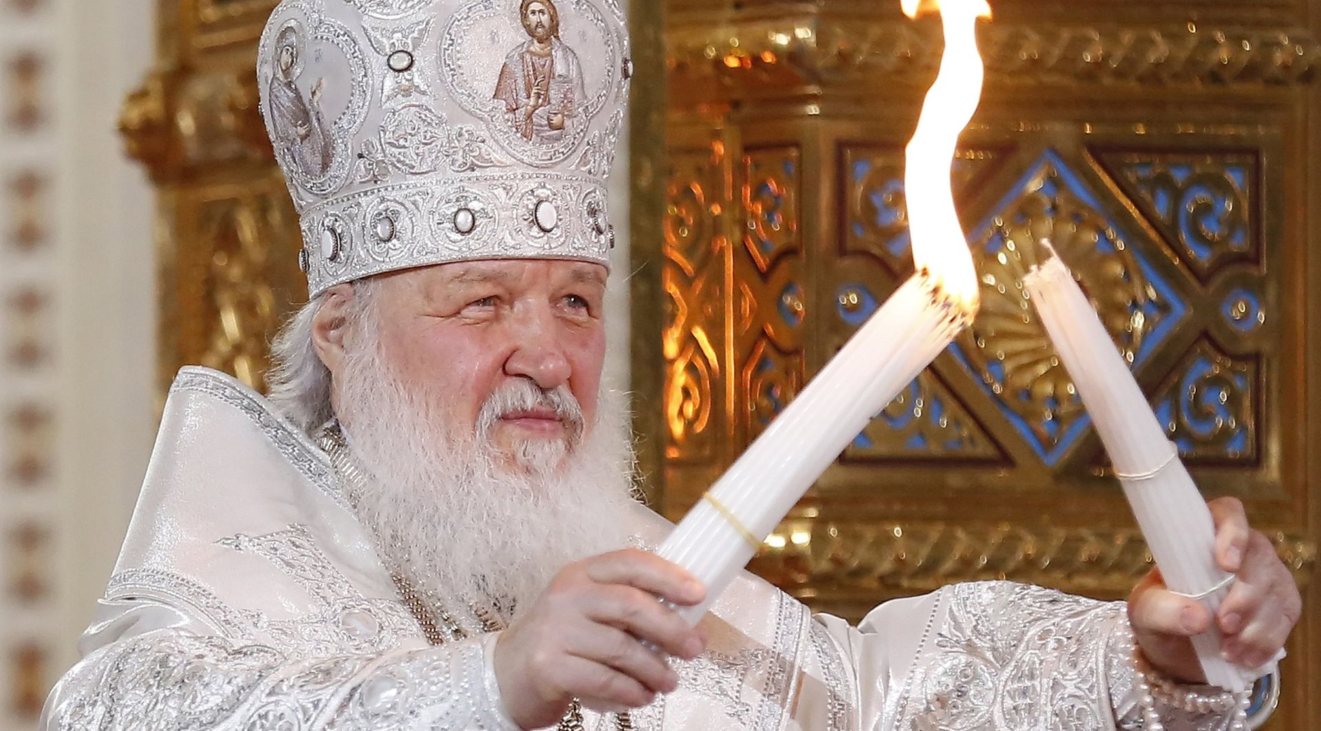 epa06653778 Patriarch Kirill of Moscow and All Russia burns candles from the Holy Fire brought from Jerusalem during the Orthodox Easter holiday service at the Christ the Savior Cathedral in Moscow, Russia, late 07 April 2018.  EPA/SERGEI ILNITSKY